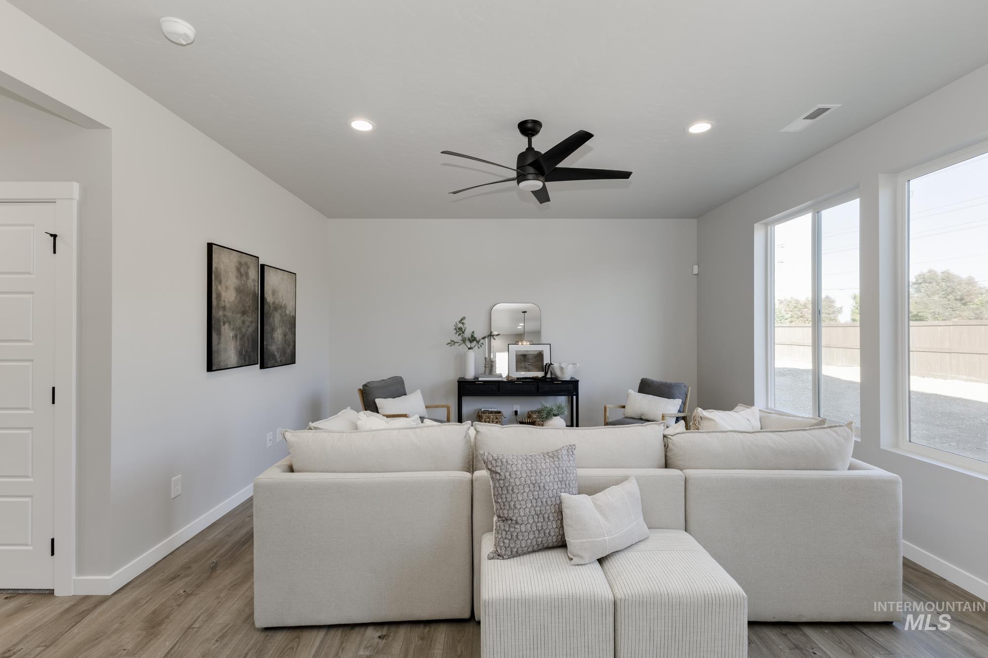 Living area featuring light wood finished floors, ceiling fan, and recessed lighting