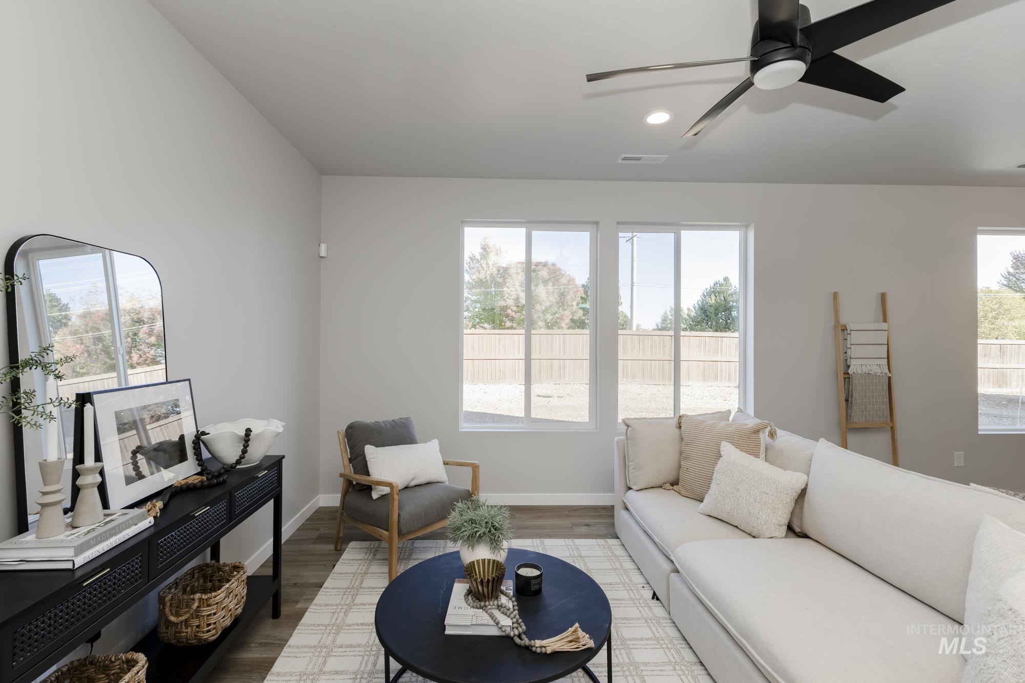 Living area featuring plenty of natural light, wood finished floors, ceiling fan, and recessed lighting