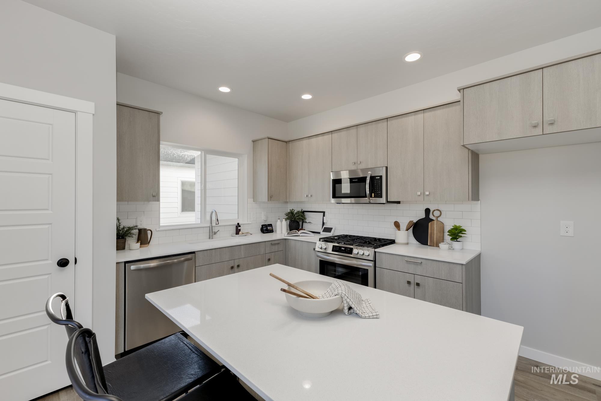 Kitchen featuring light wood finished floors, stainless steel appliances, light brown cabinets, and recessed lighting