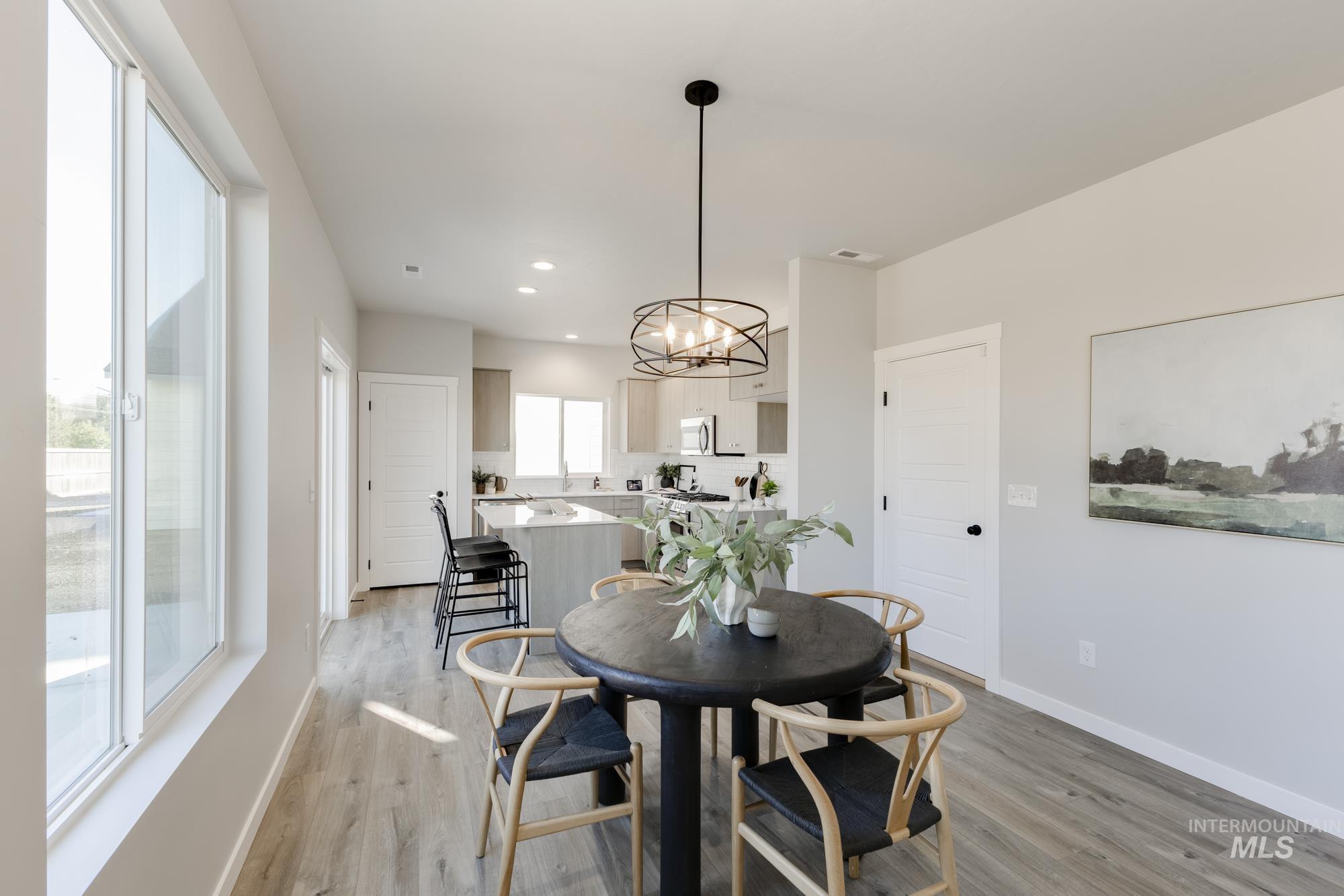 Dining space with a chandelier, light wood-style flooring, and recessed lighting