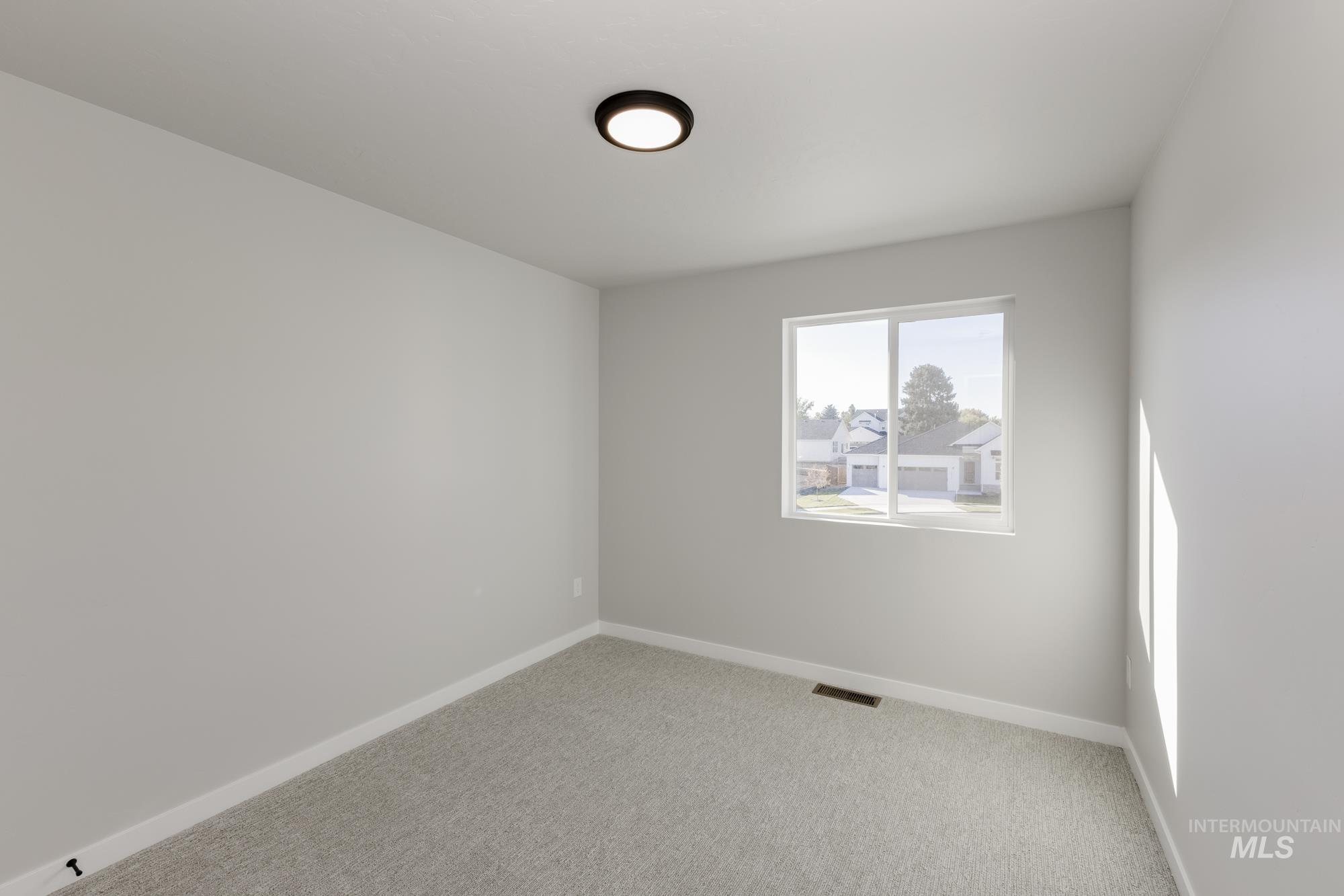 Carpeted empty room featuring baseboards