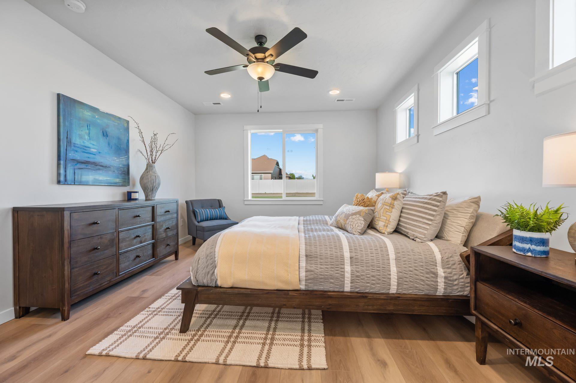 Bedroom featuring light wood-style flooring, a ceiling fan, and recessed lighting