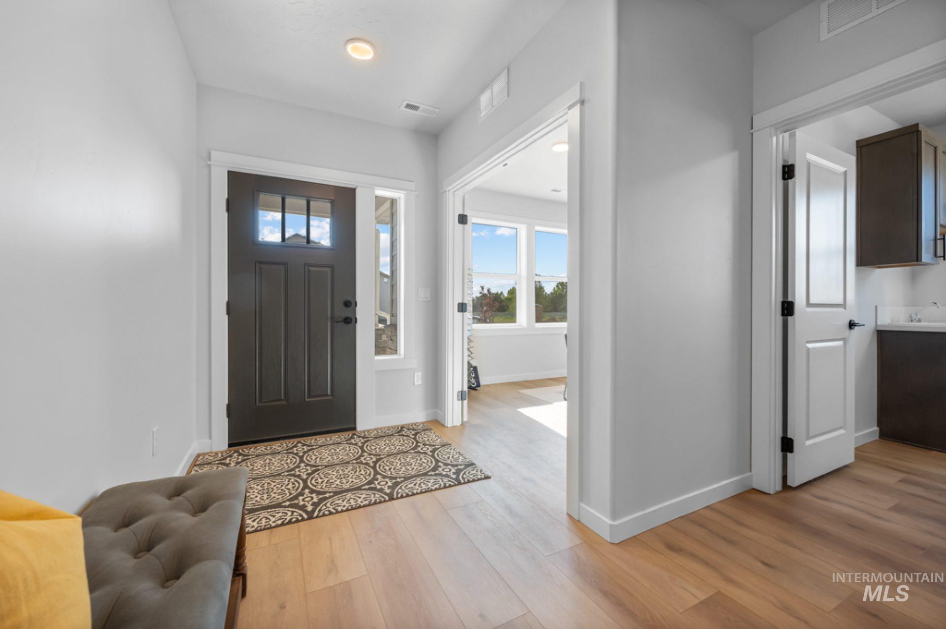 Entrance foyer with light wood-type flooring and baseboards