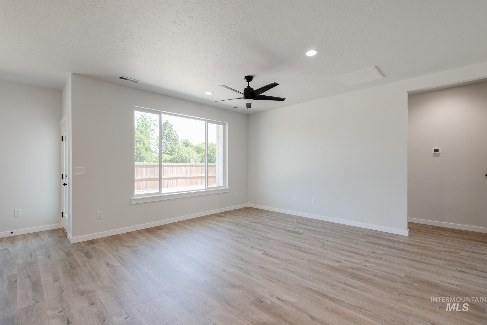 Empty room featuring light wood-type flooring, ceiling fan, and recessed lighting