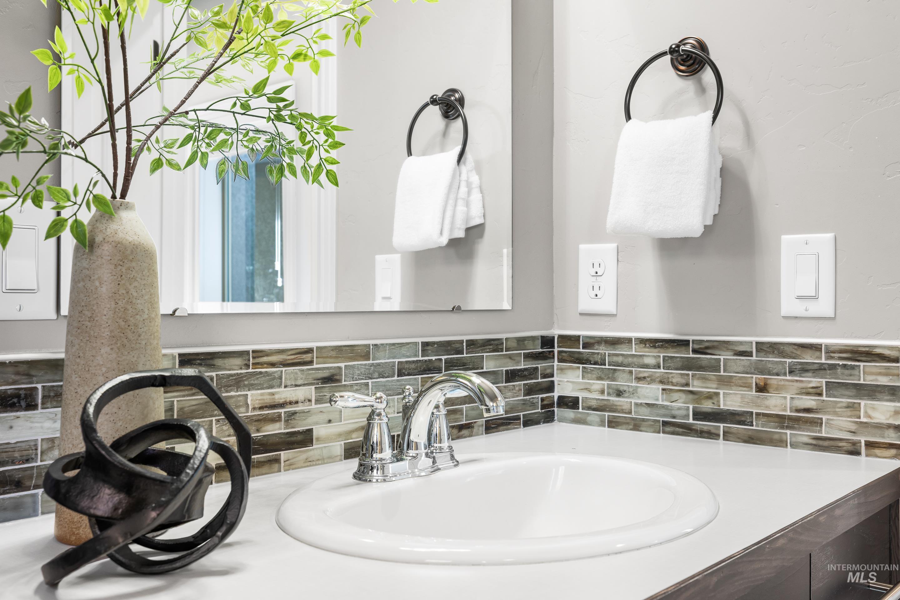 Bathroom with vanity and decorative backsplash