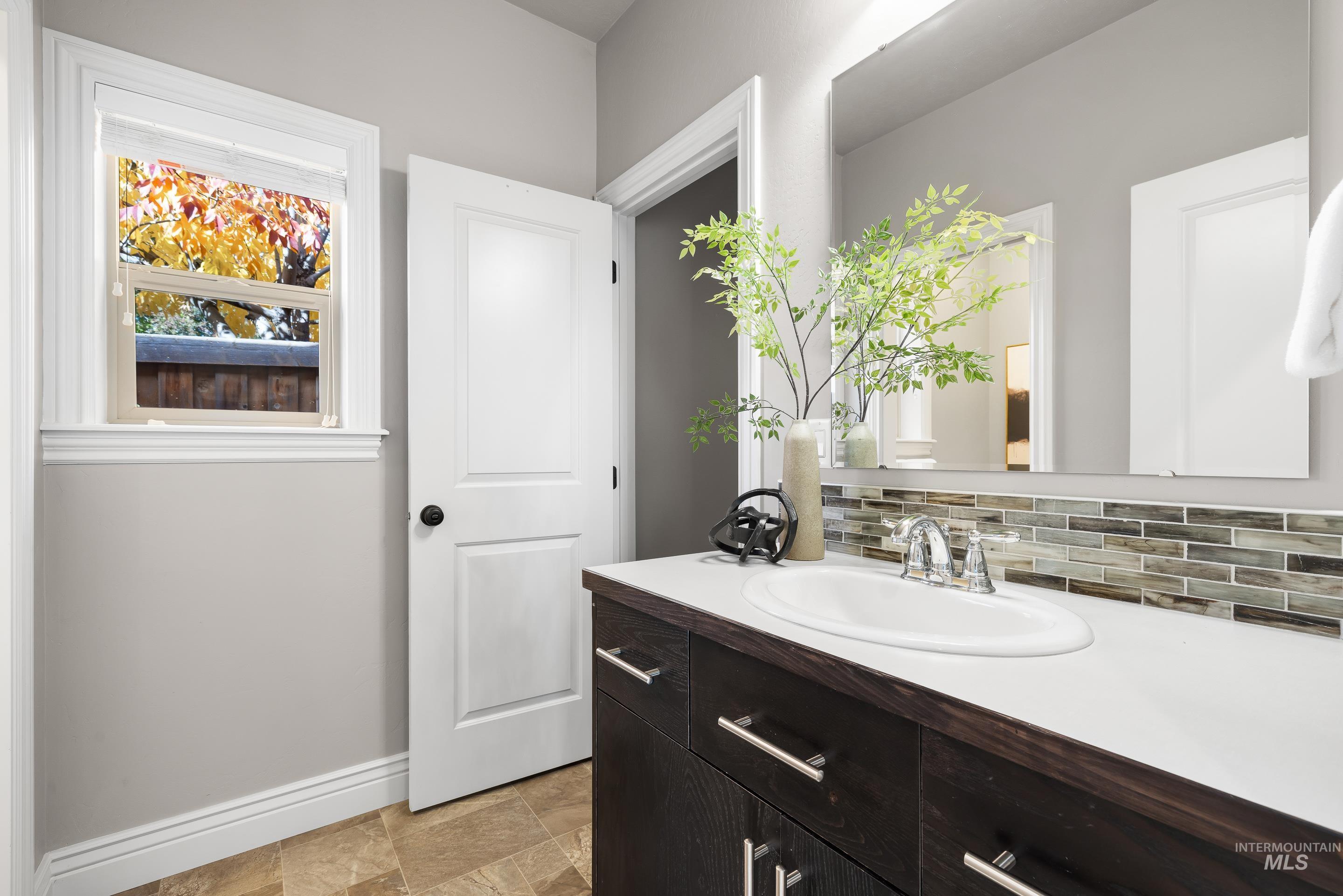 Bathroom with vanity and backsplash
