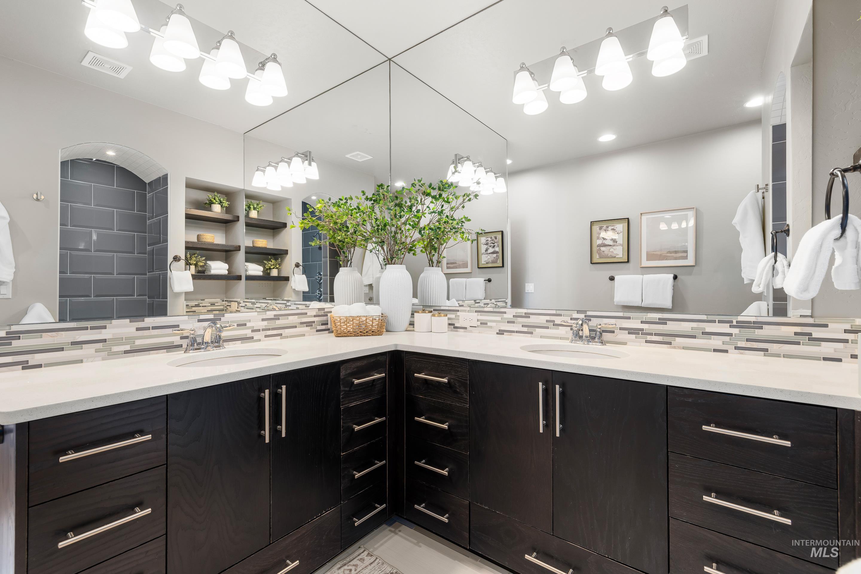 Full bath featuring double vanity, tasteful backsplash, and recessed lighting
