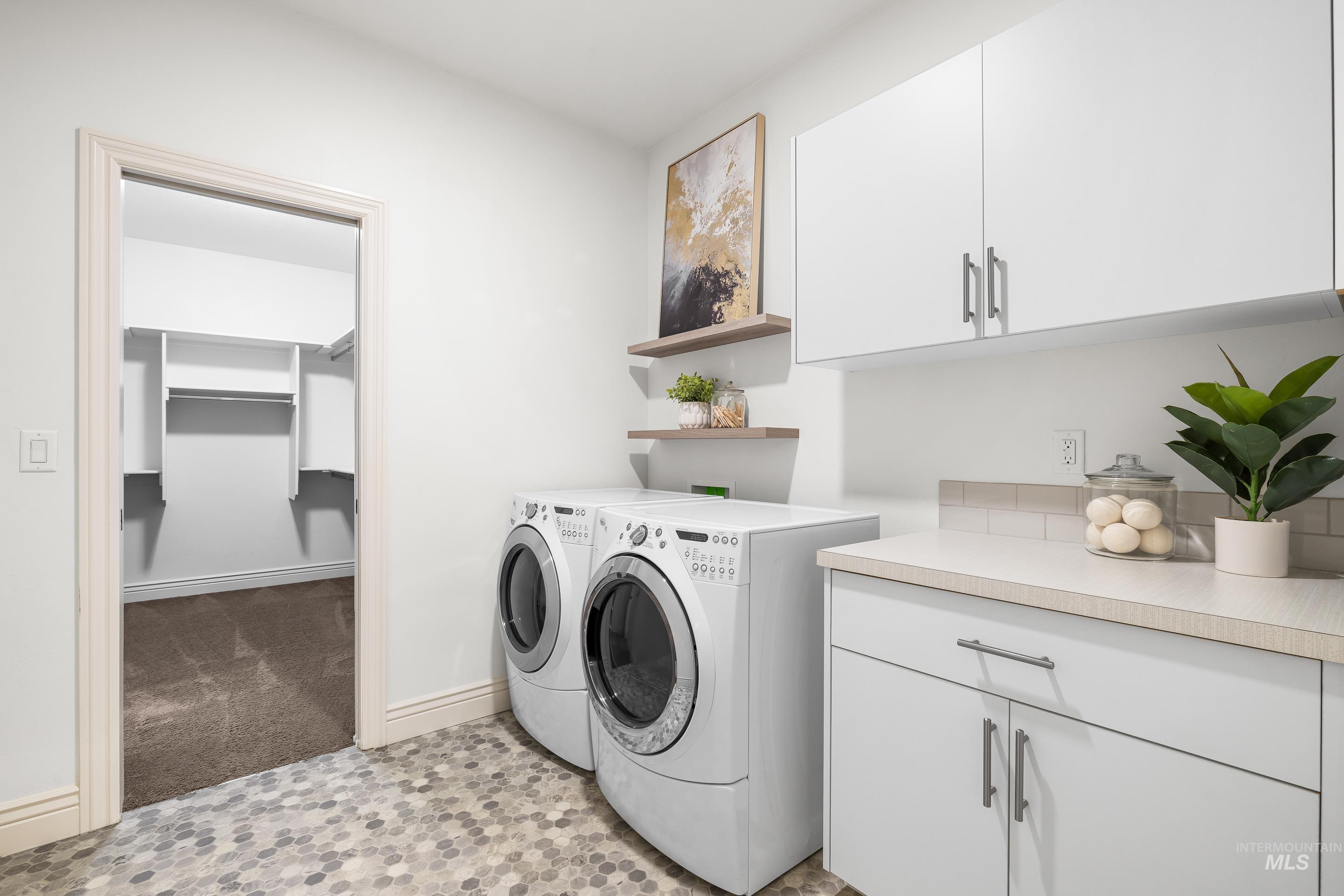 Laundry area with separate washer and dryer and cabinet space