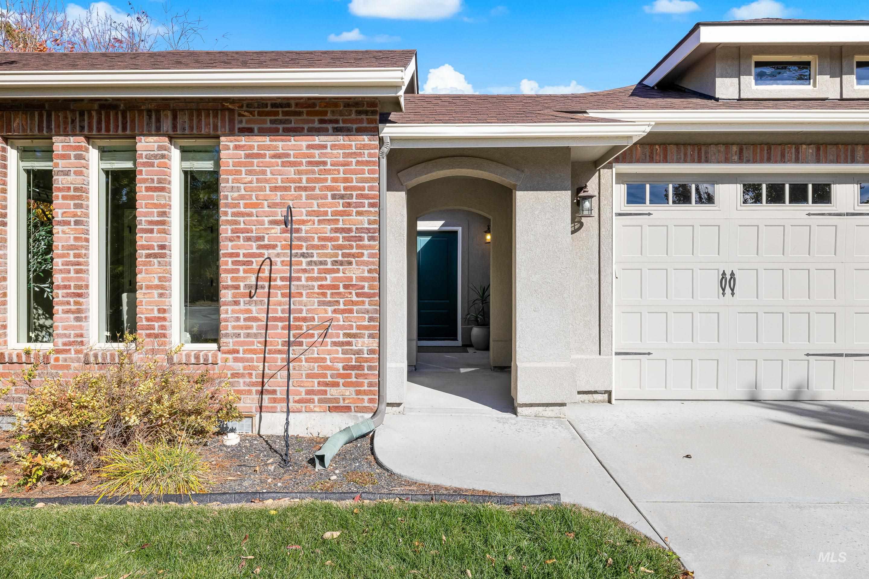 Doorway to property with brick siding and roof with shingles