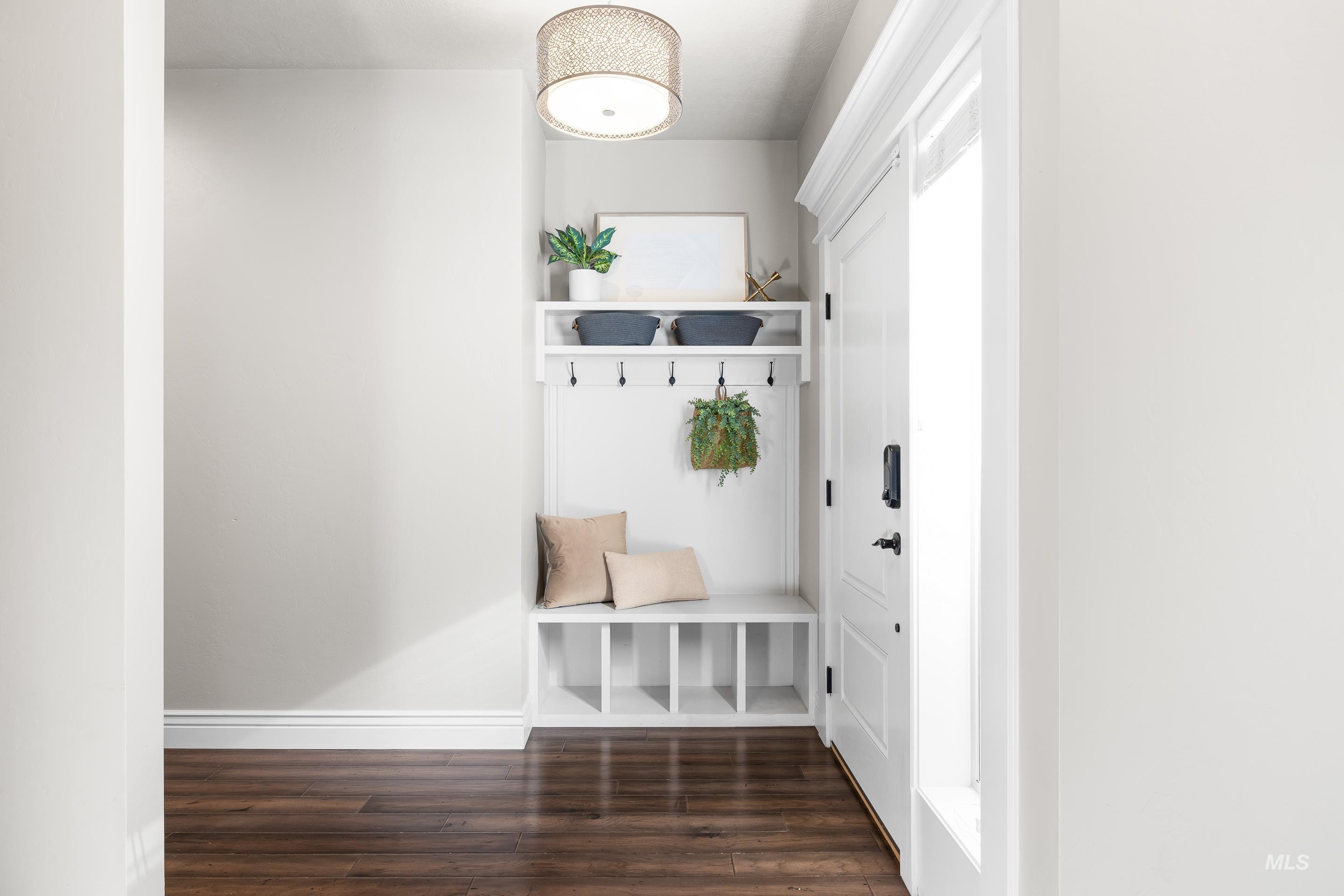 Mudroom featuring dark wood-style floors and baseboards