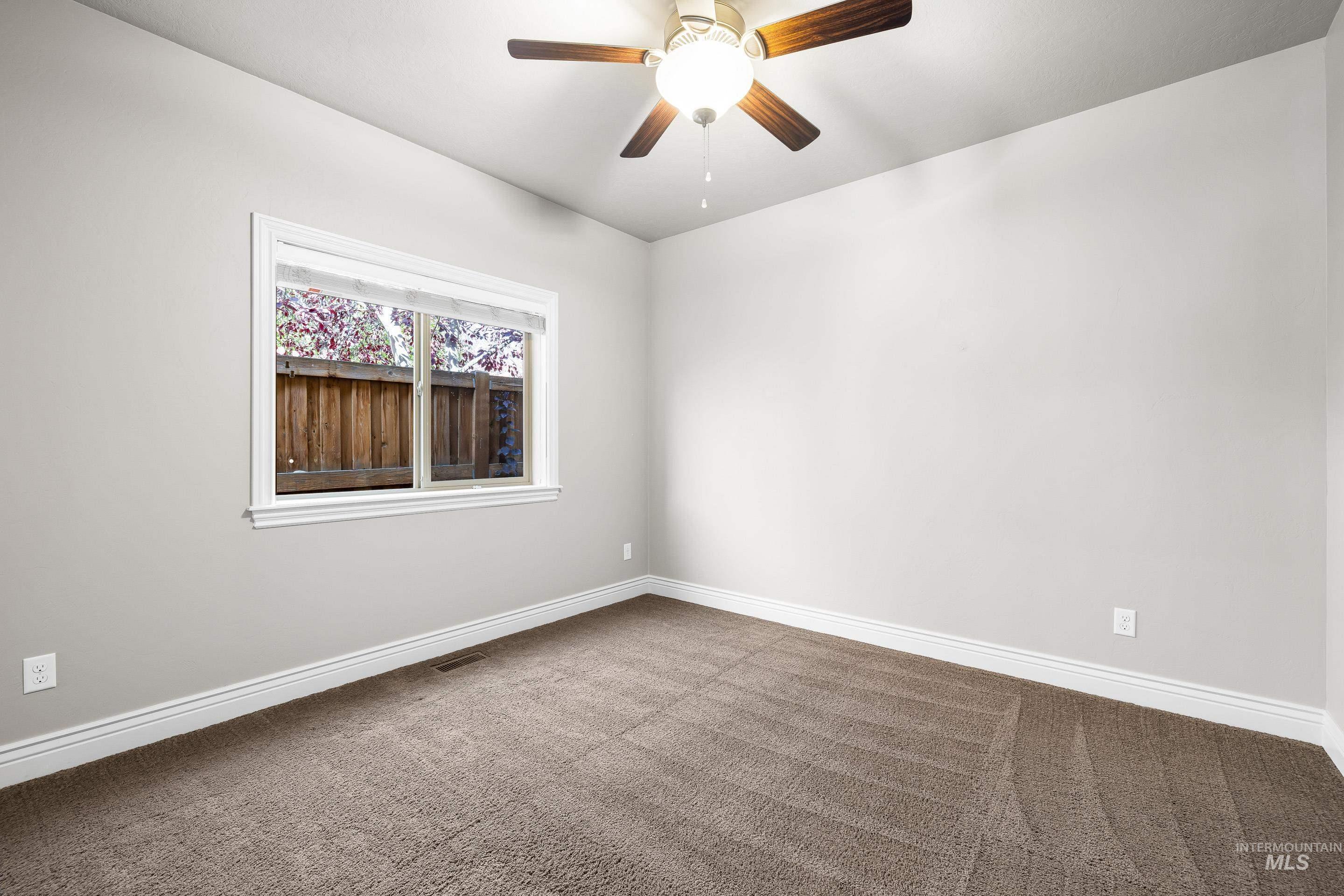 Unfurnished room featuring carpet flooring and a ceiling fan
