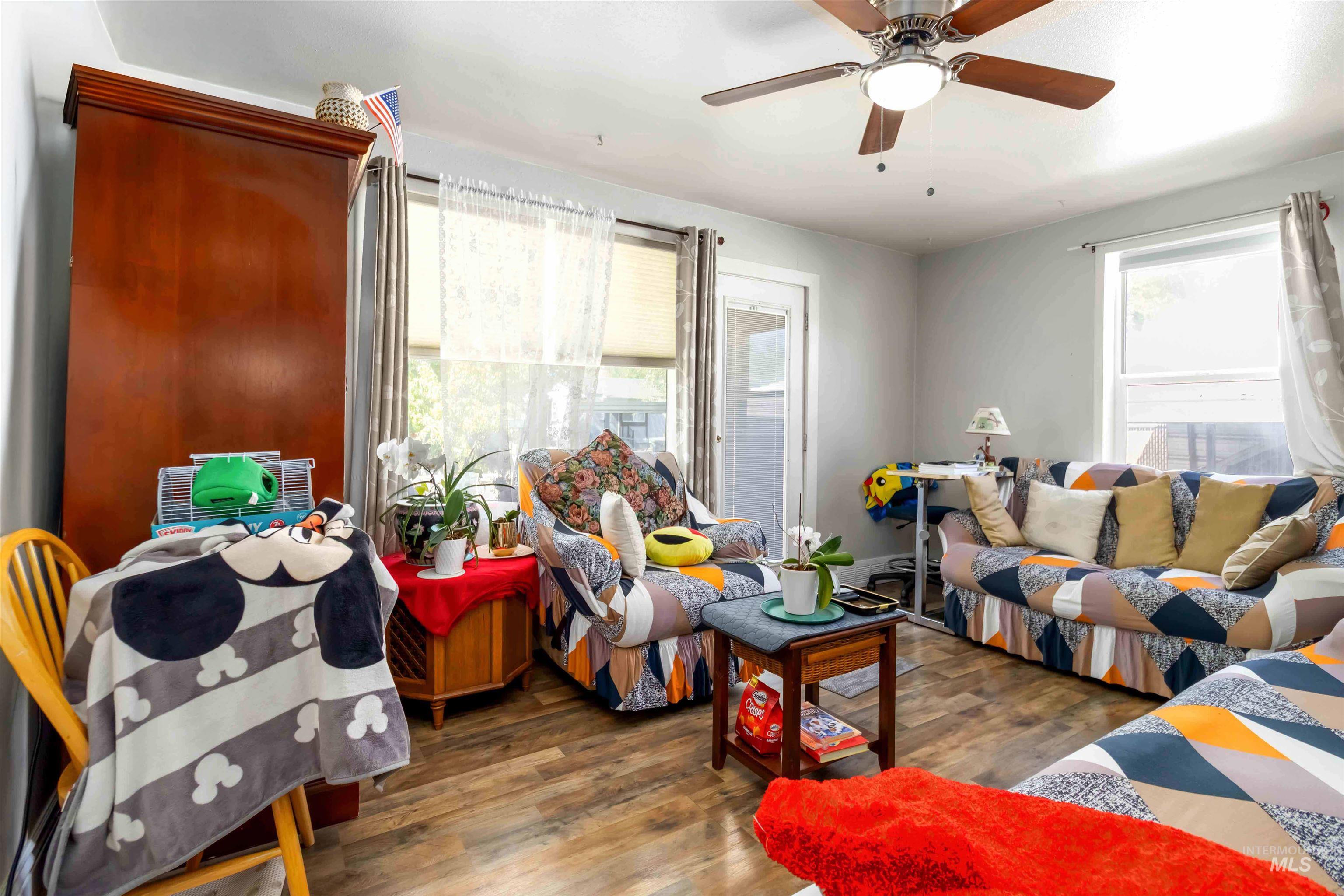 Living area featuring wood finished floors and a ceiling fan