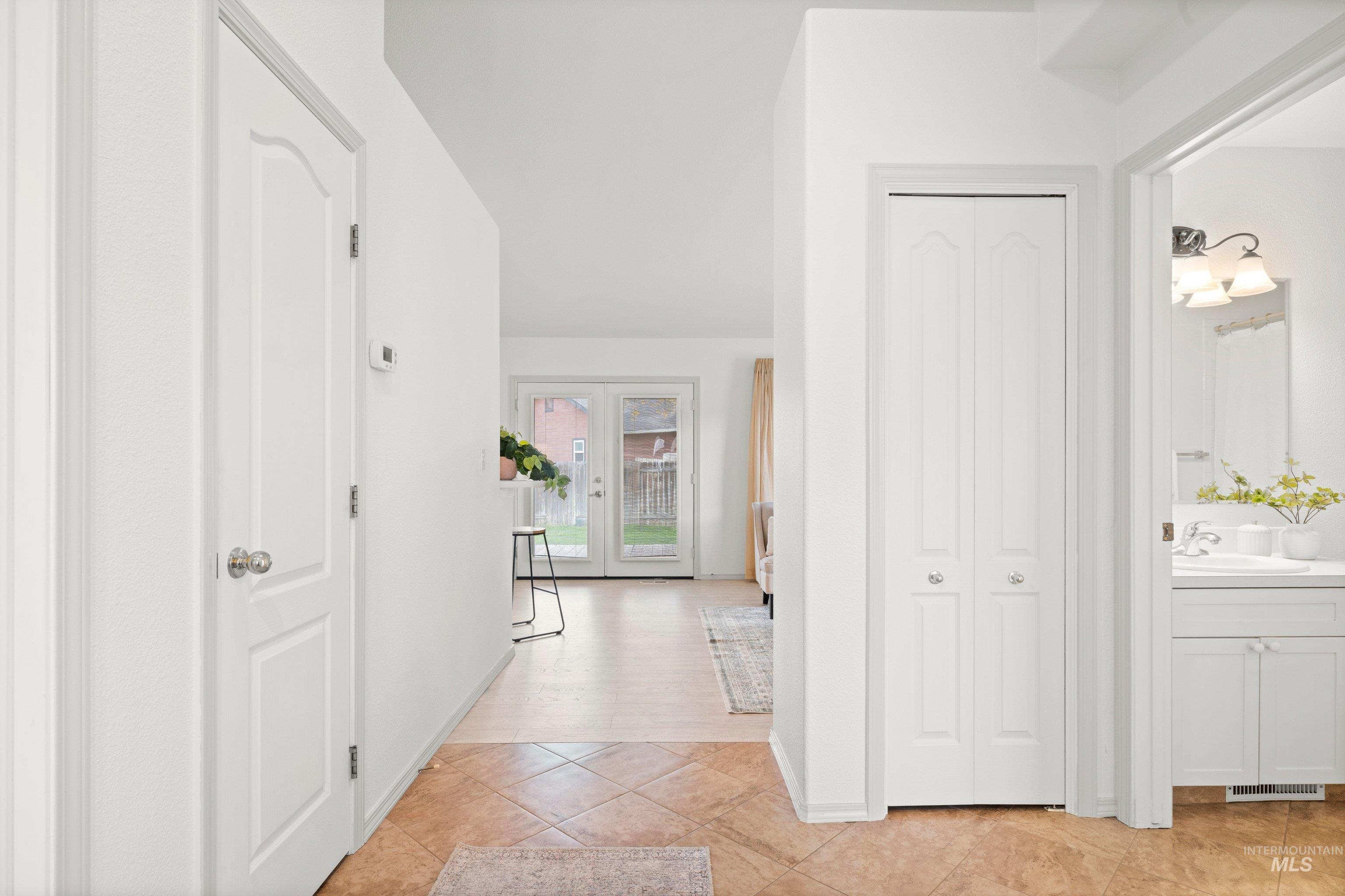 Hallway featuring light tile patterned floors and french doors