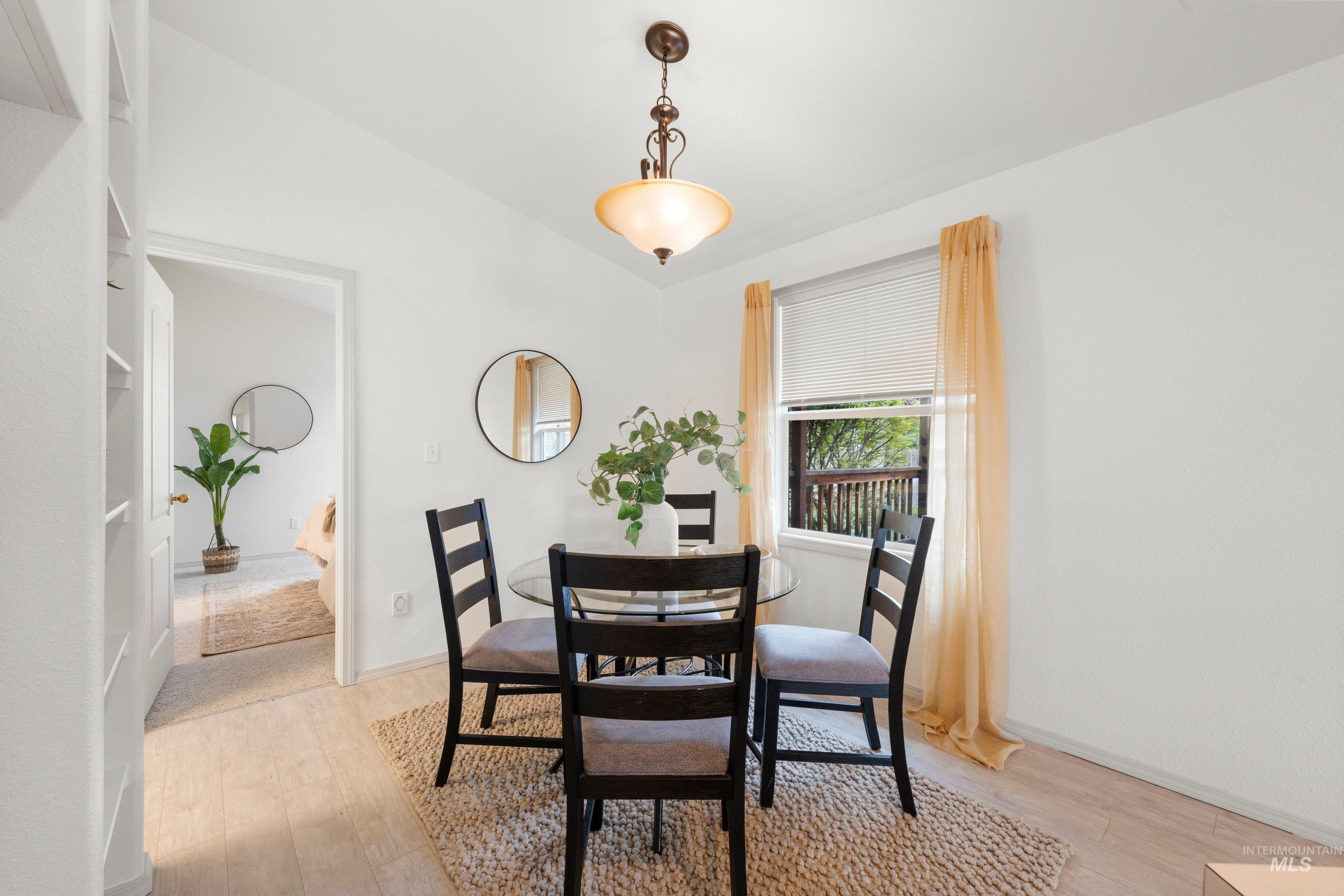 Dining area featuring light wood-style flooring and lofted ceiling