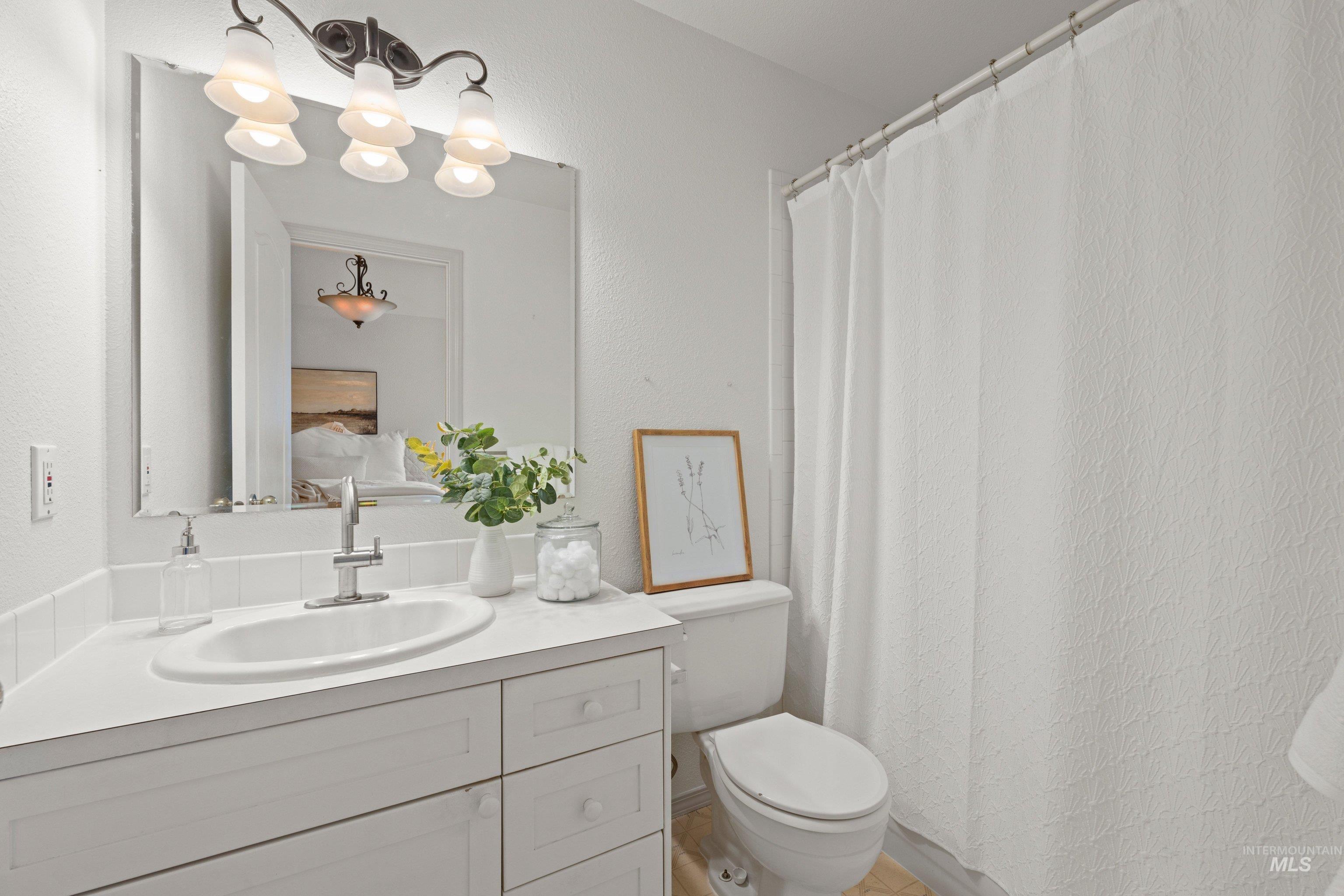 Full bathroom with vanity, curtained shower, and a textured wall