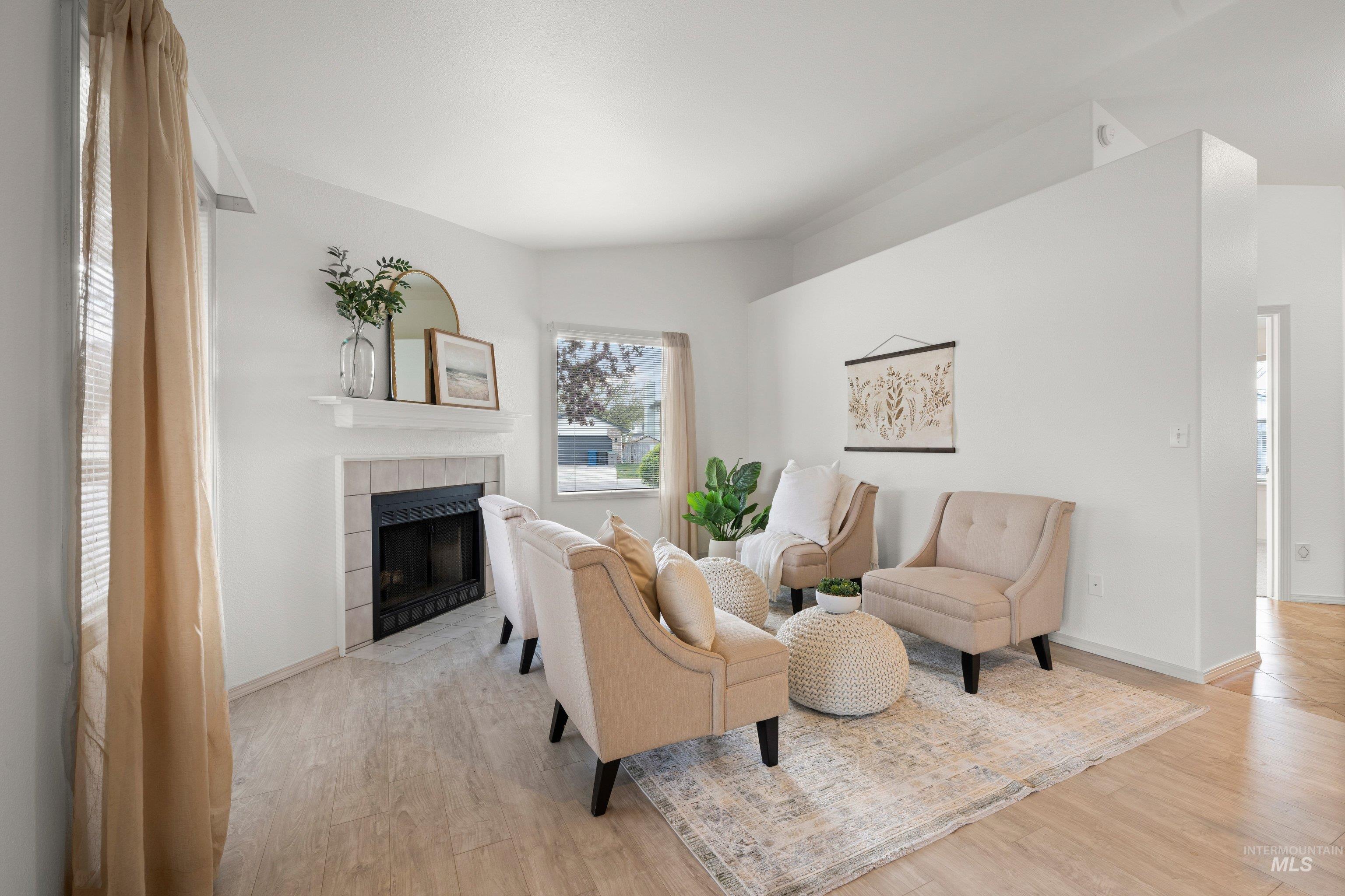 Living room with light wood finished floors and a tiled fireplace
