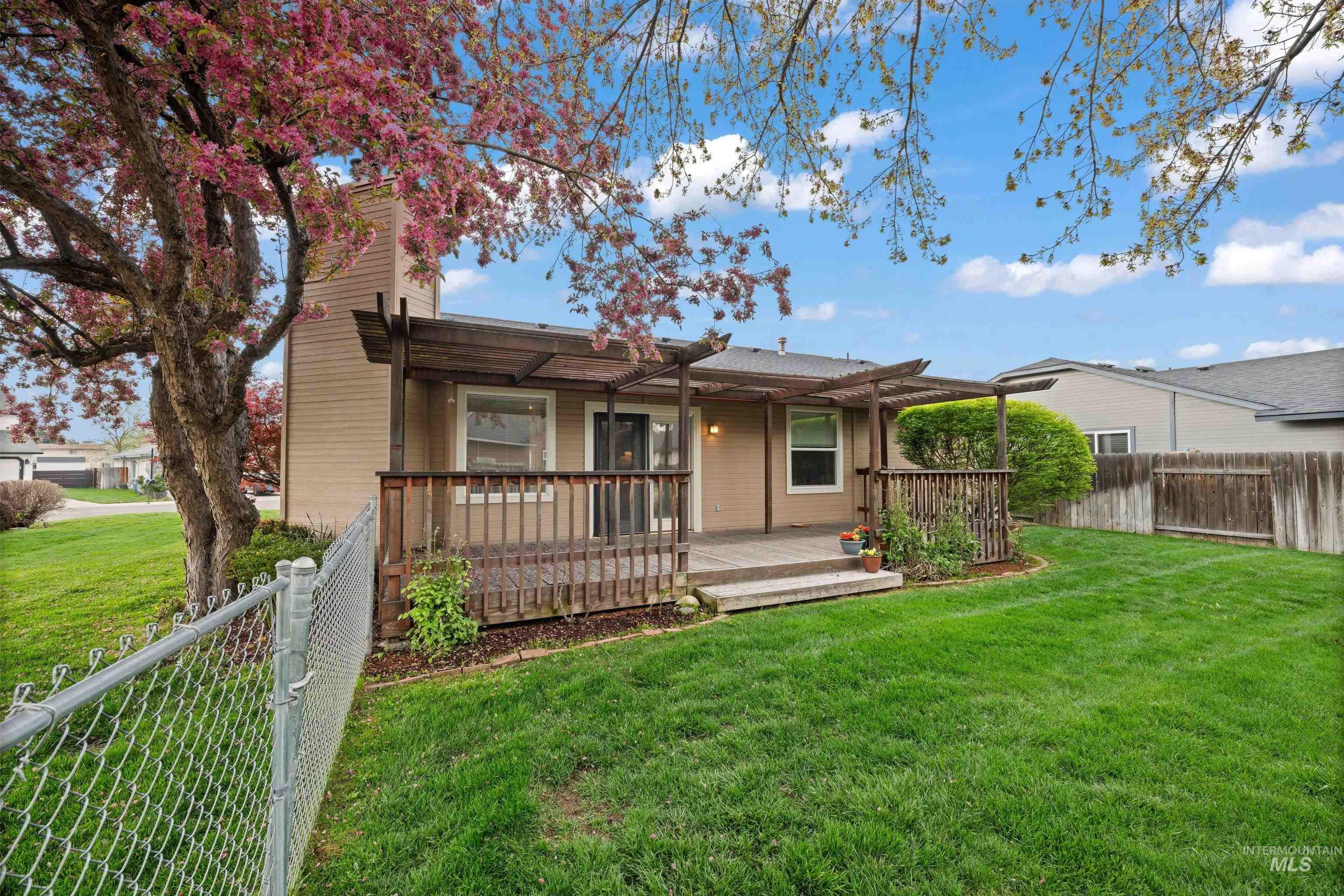 Rear view of property featuring a fenced backyard, a wooden deck, and a chimney