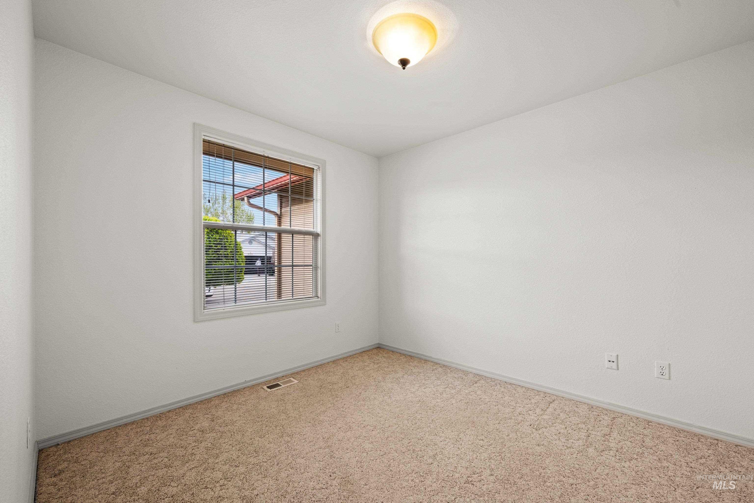 Carpeted empty room featuring baseboards