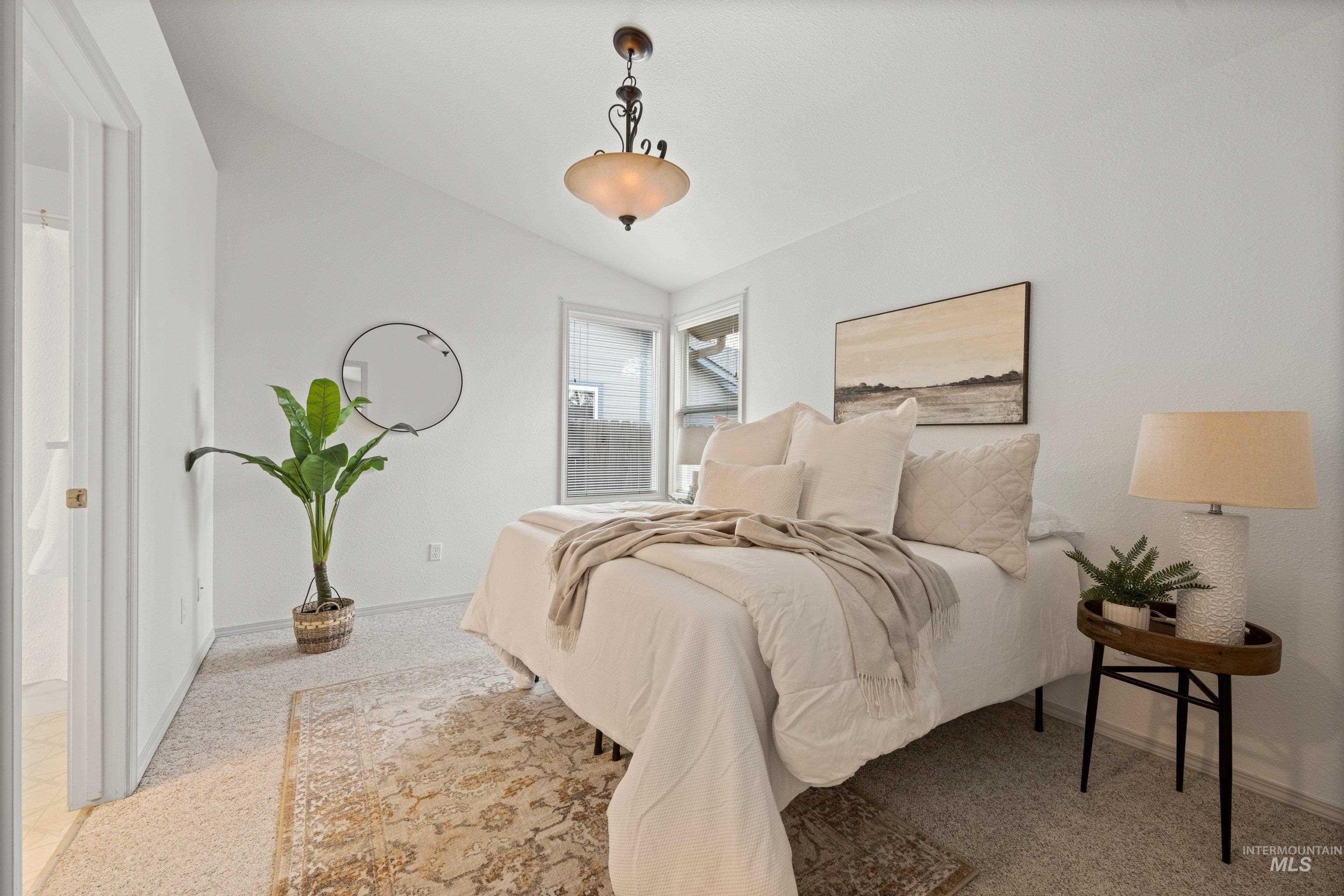 Bedroom with lofted ceiling and light colored carpet