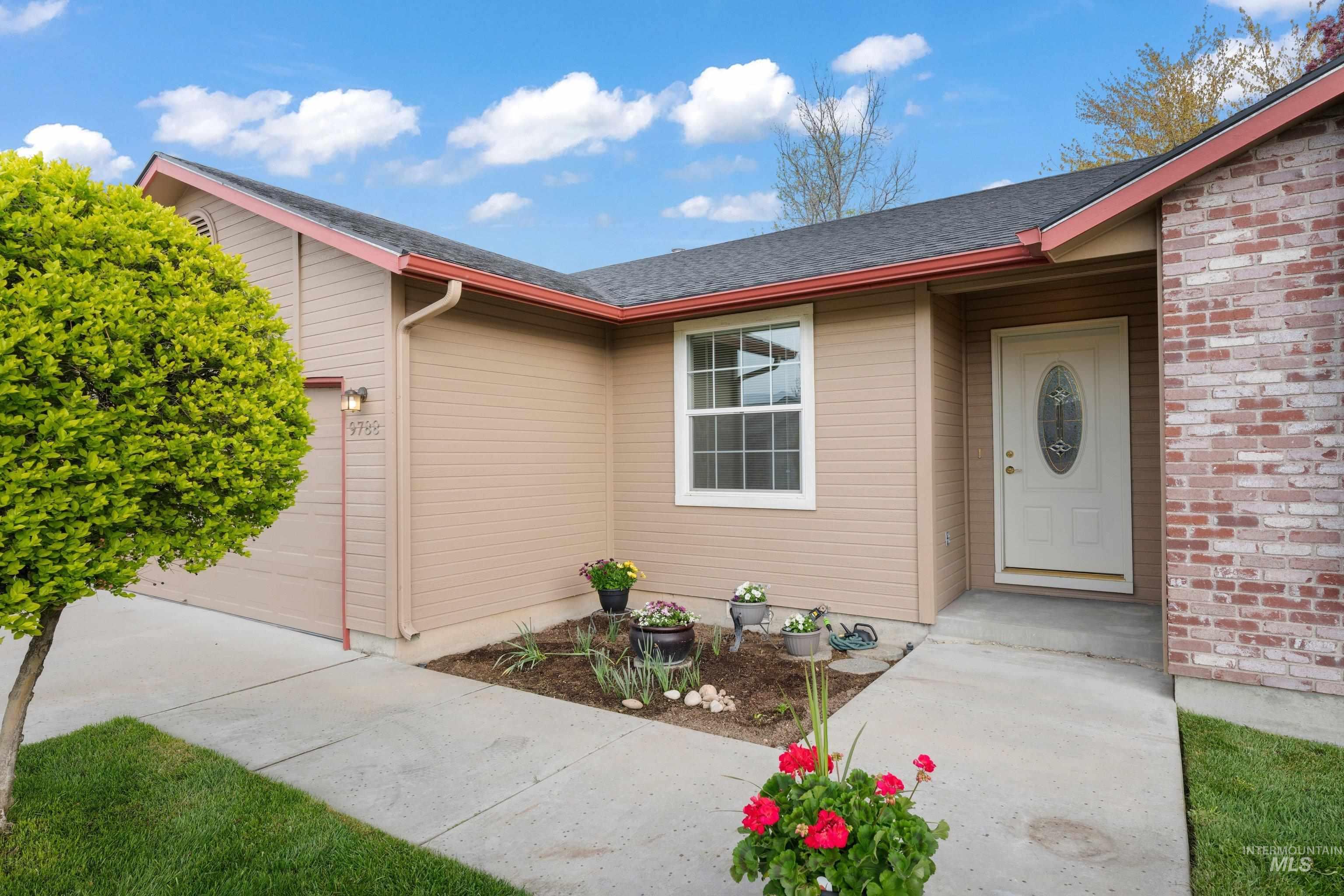 Property entrance featuring a garage and a shingled roof