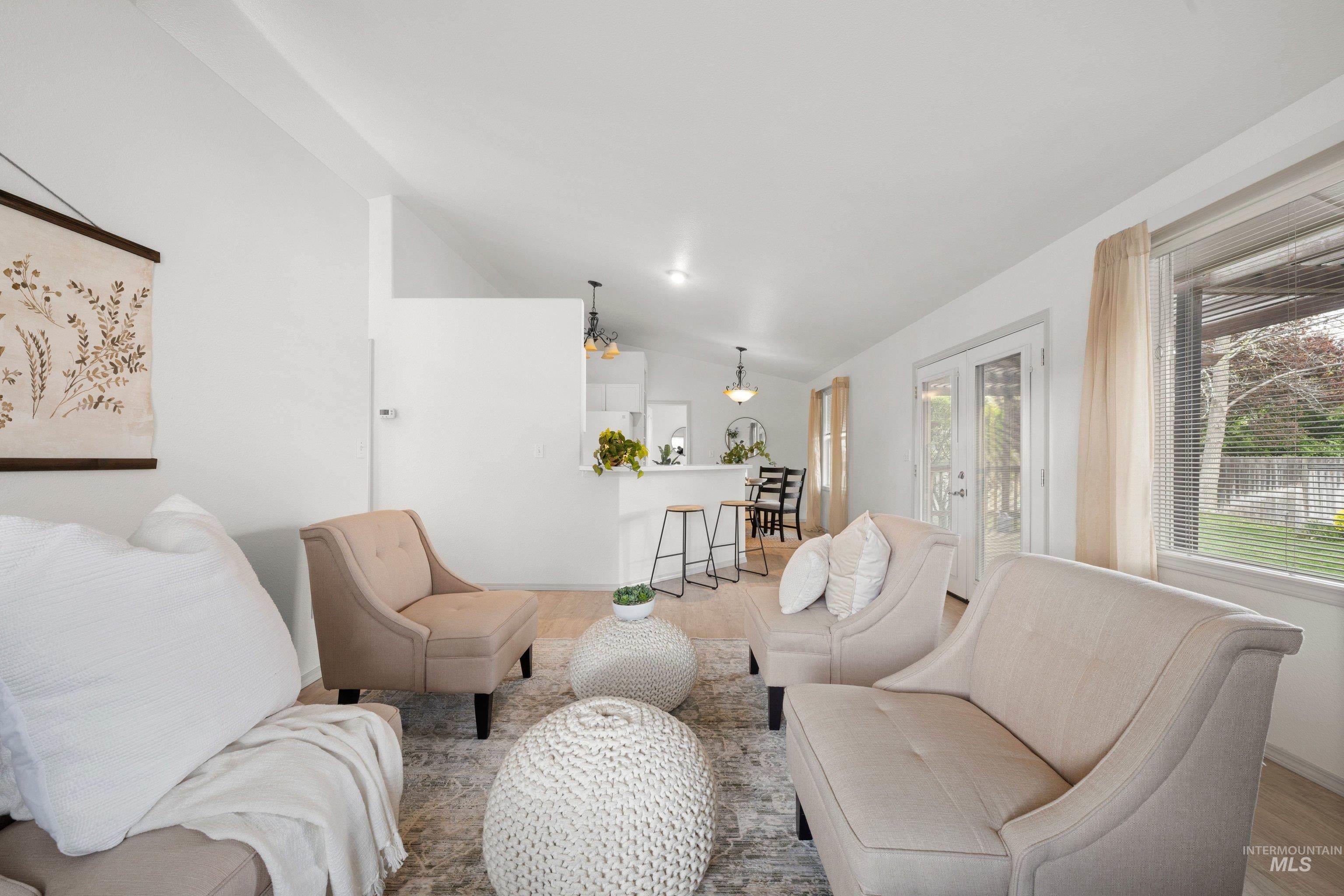 Living area featuring vaulted ceiling, french doors, and light wood finished floors