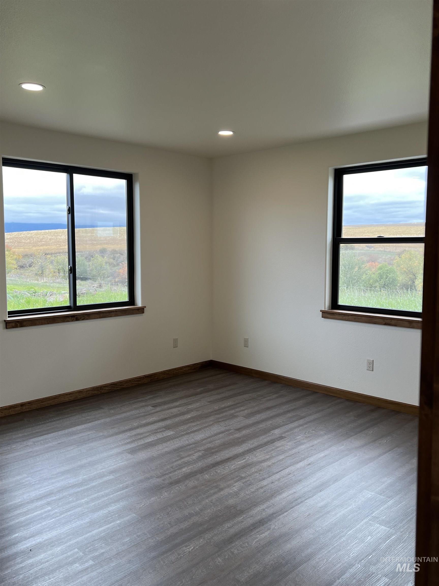 Unfurnished room featuring wood finished floors, healthy amount of natural light, and recessed lighting
