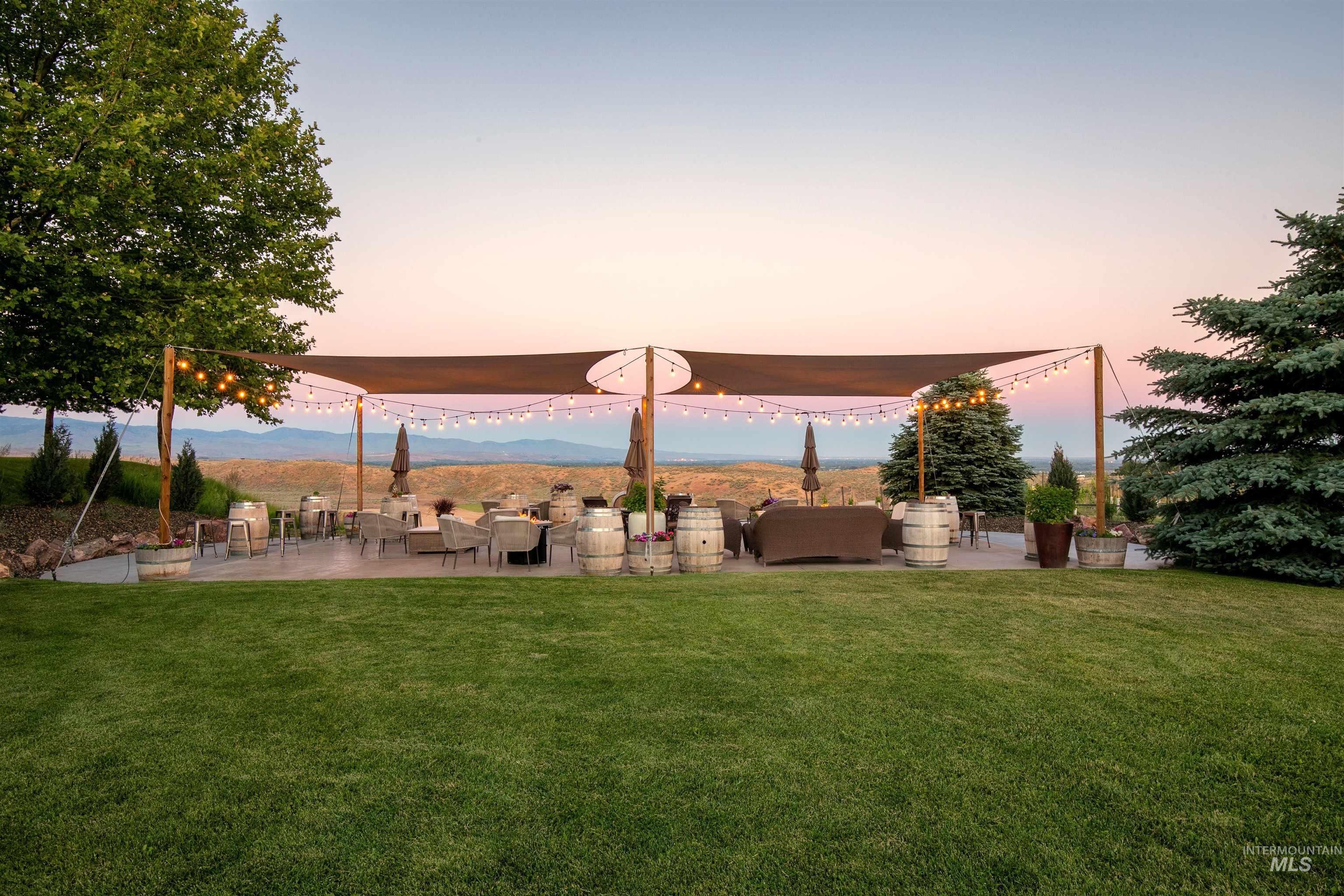 View of green lawn with a patio and a mountain view
