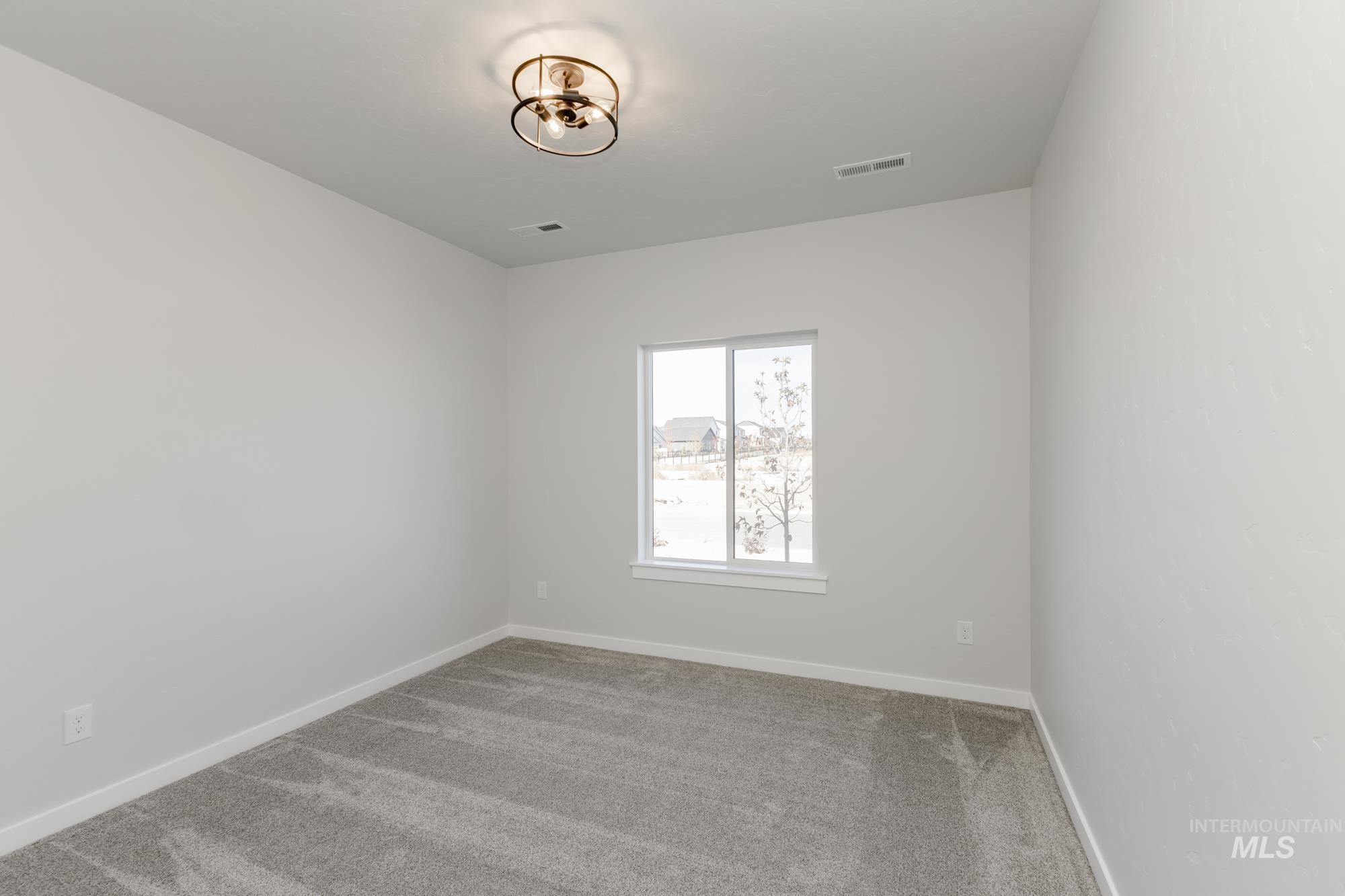 Carpeted spare room with baseboards