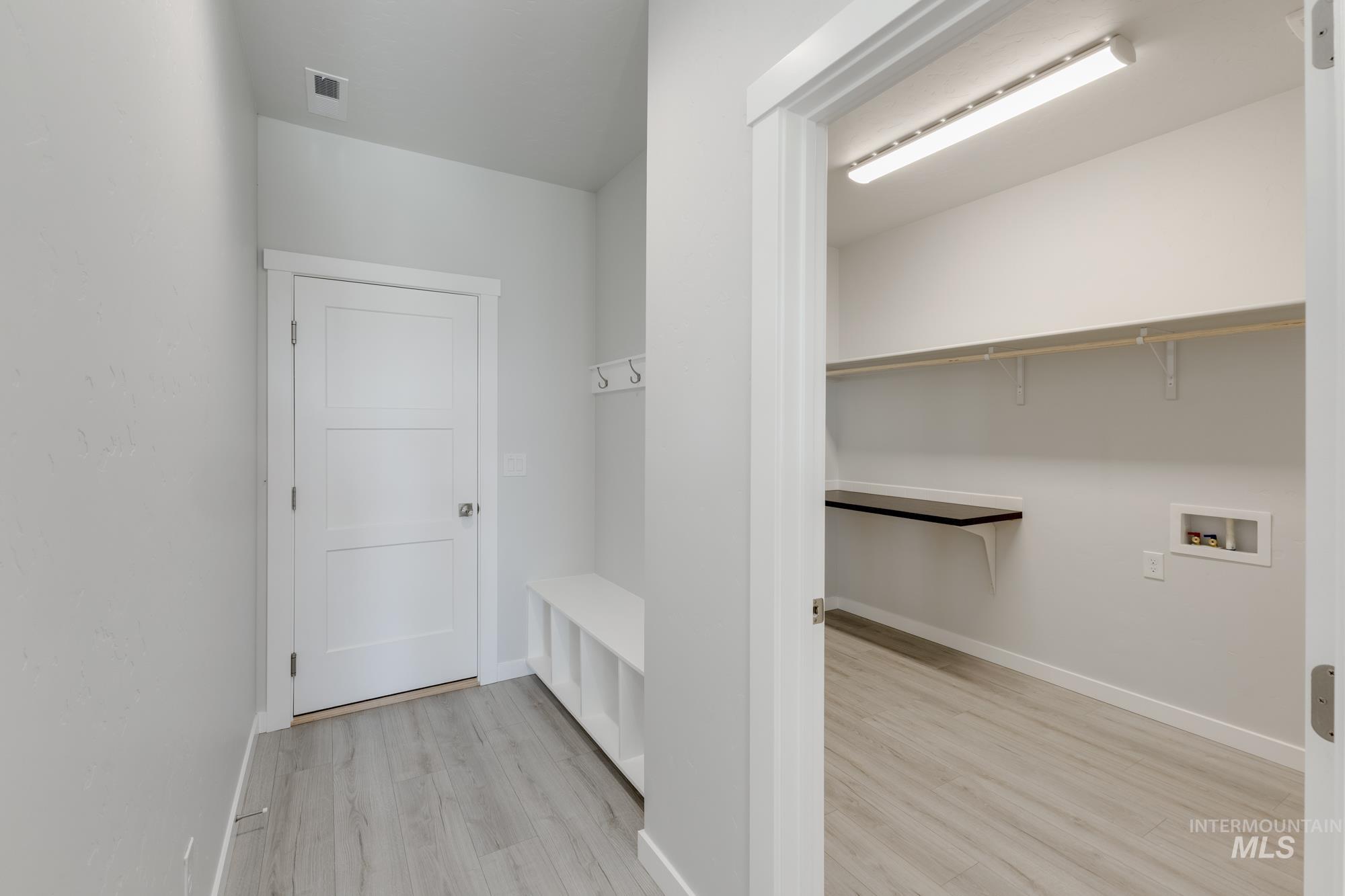 Laundry area with light wood-style floors and washer hookup