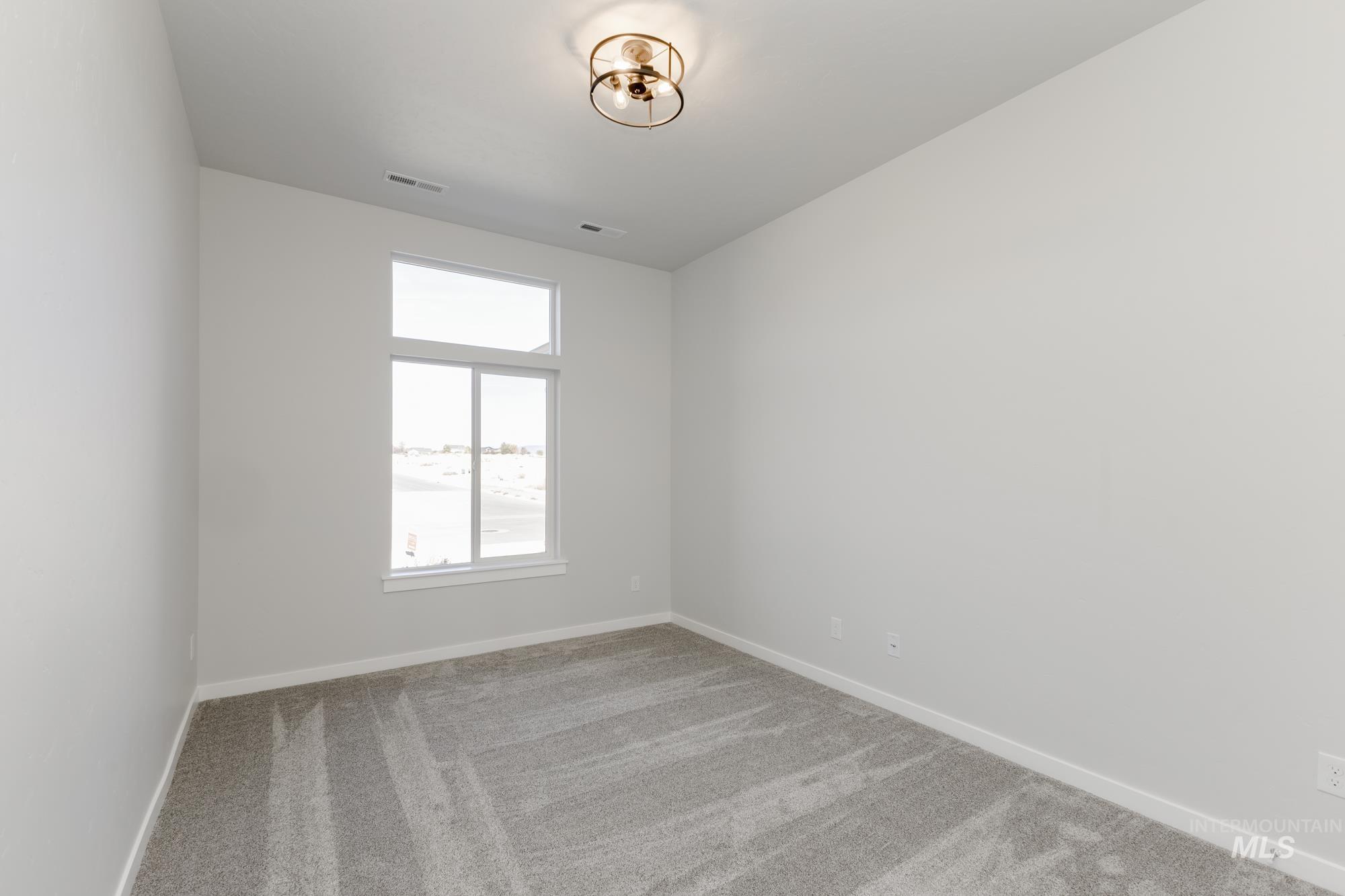 Empty room featuring light carpet and baseboards