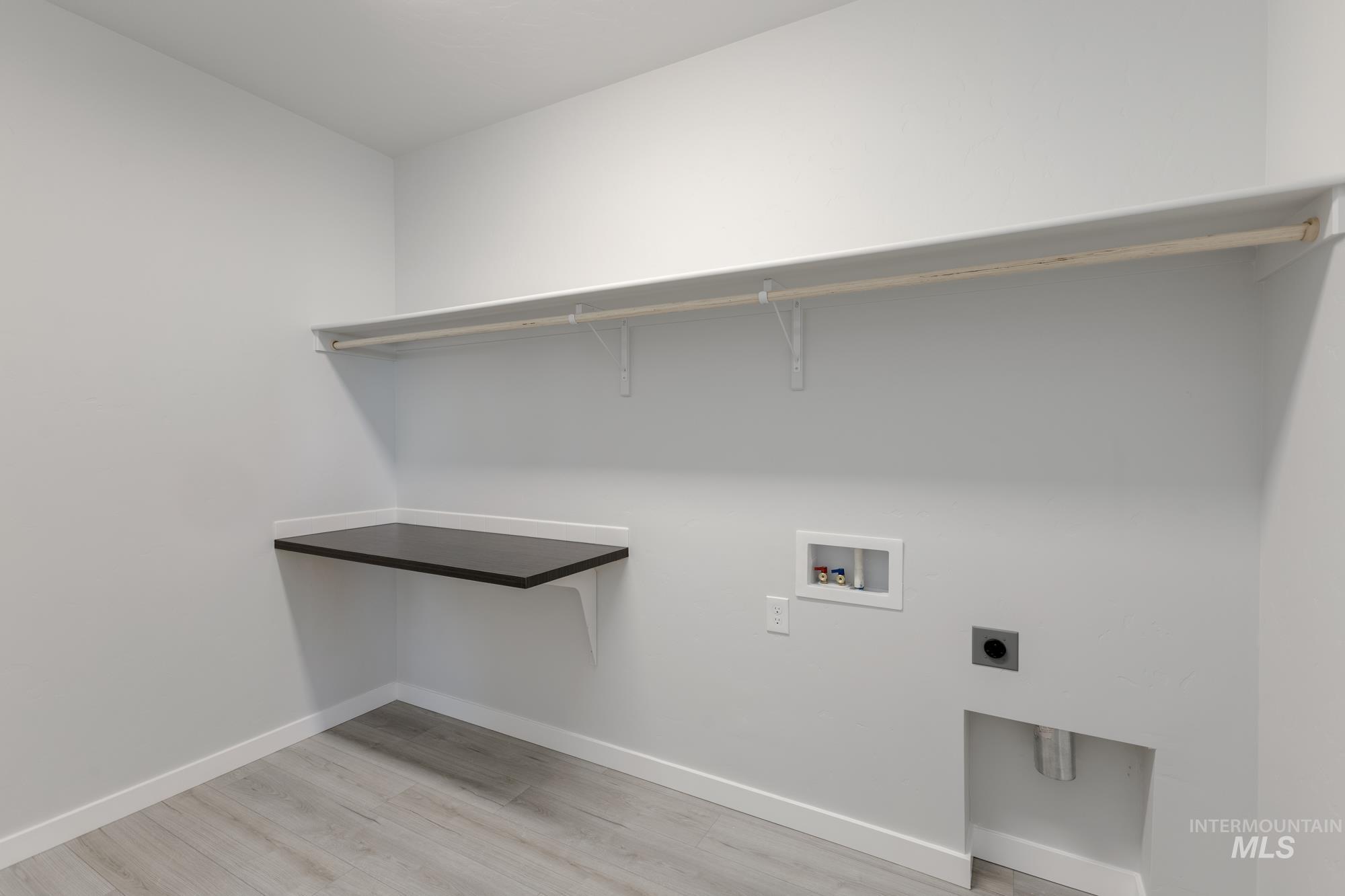 Washroom featuring light wood-style flooring, washer hookup, and hookup for an electric dryer