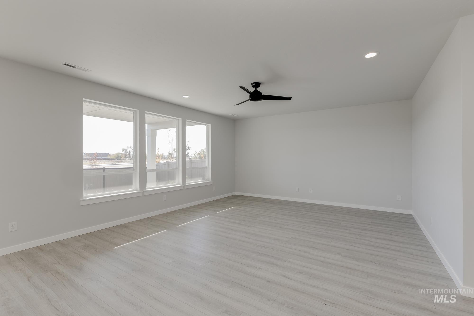 Empty room featuring light wood-style flooring, recessed lighting, and ceiling fan