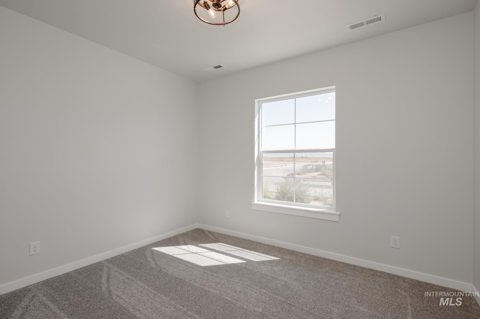 Carpeted empty room with baseboards