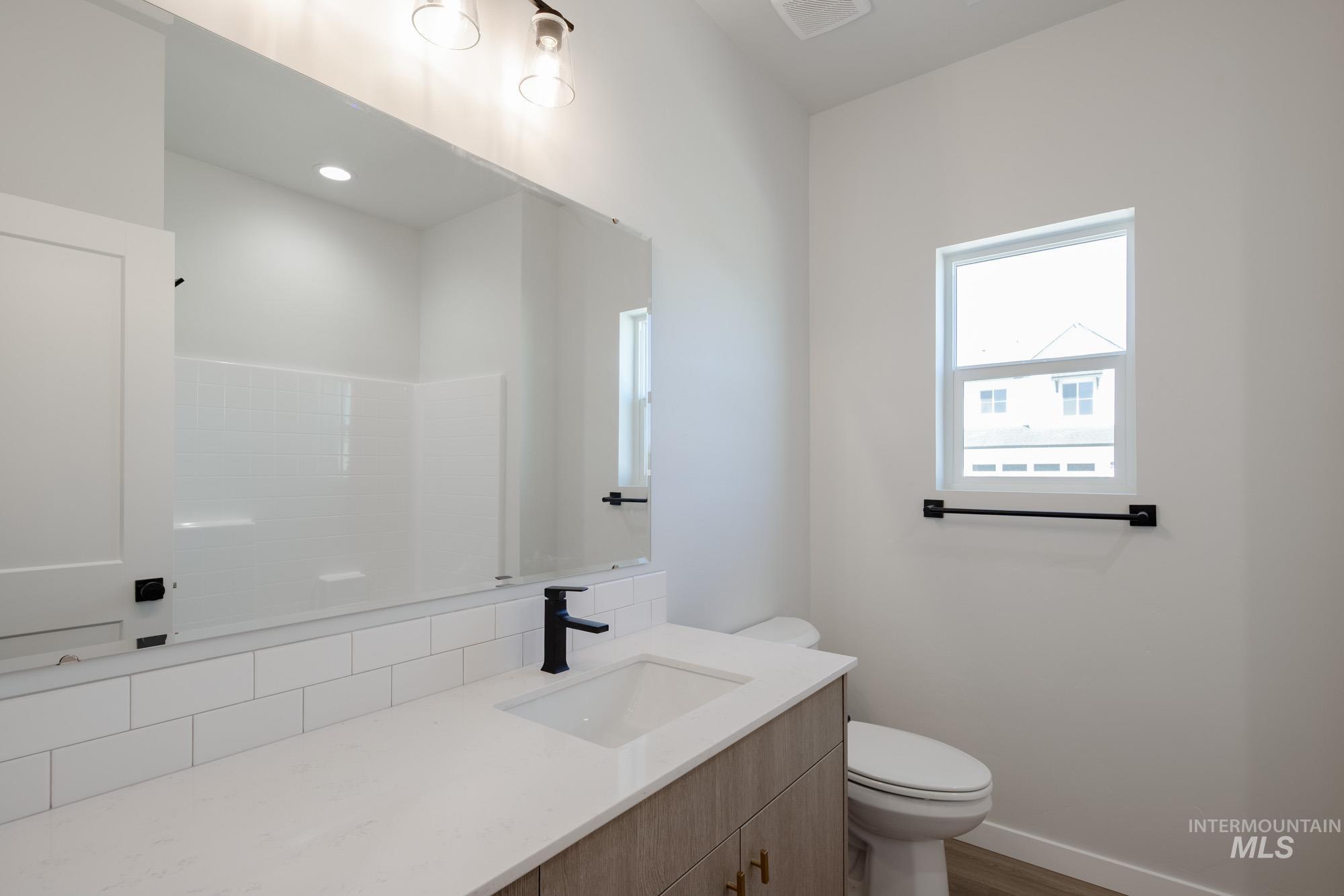 Half bathroom with vanity and dark wood-style floors