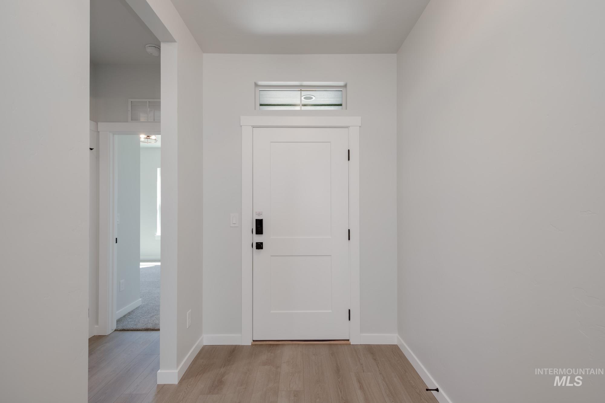 Entrance foyer with light wood-type flooring and baseboards