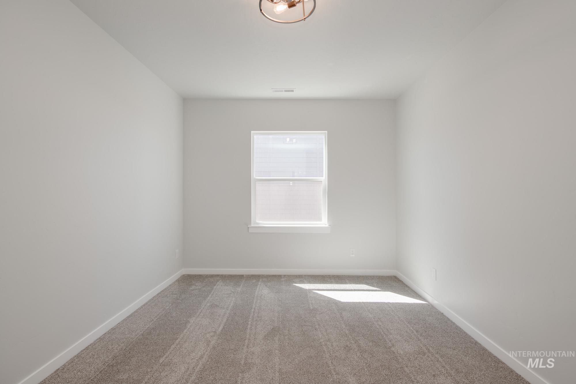 Carpeted empty room with baseboards