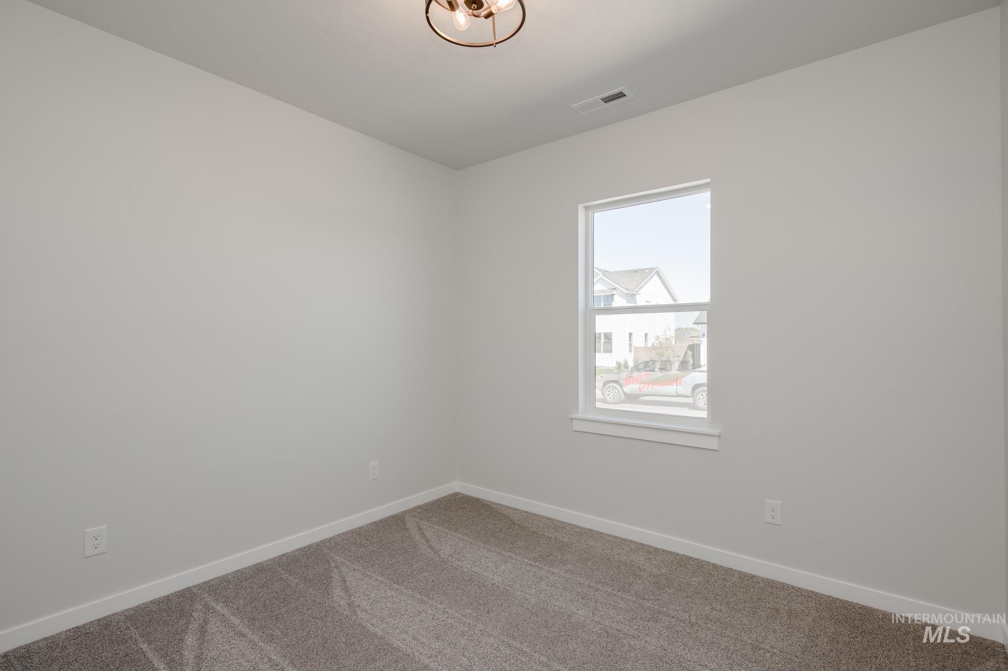 Carpeted empty room featuring baseboards