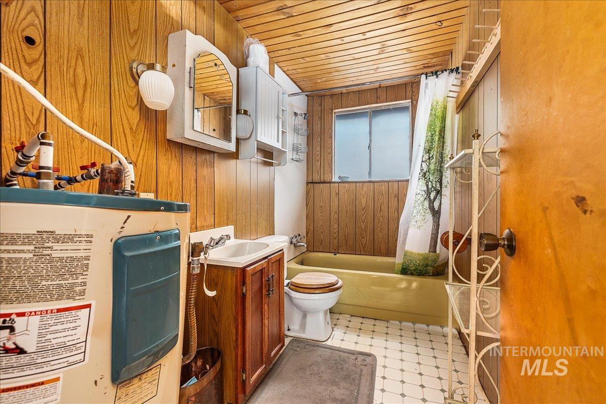 Bathroom with vanity, wooden walls, water heater, and wood ceiling