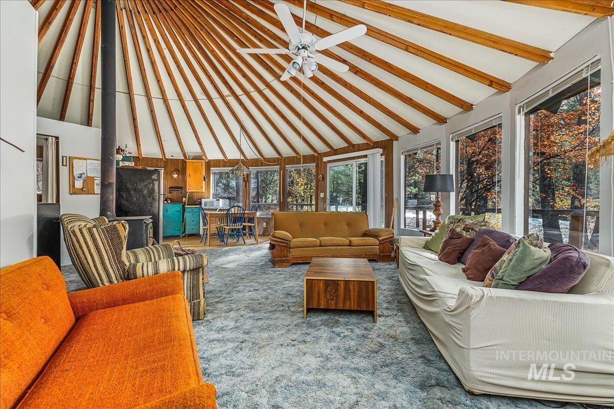 Sunroom / solarium featuring high vaulted ceiling, carpet, and beamed ceiling