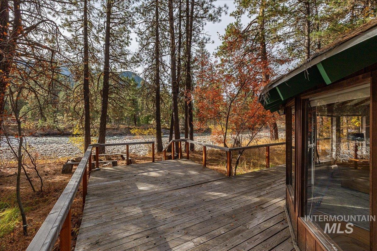 Deck with a water view and a forest view
