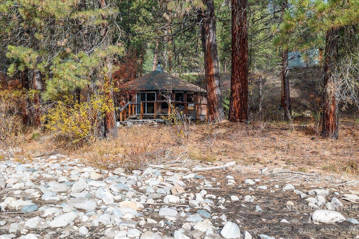 View of front of property featuring a gazebo and a wooded view