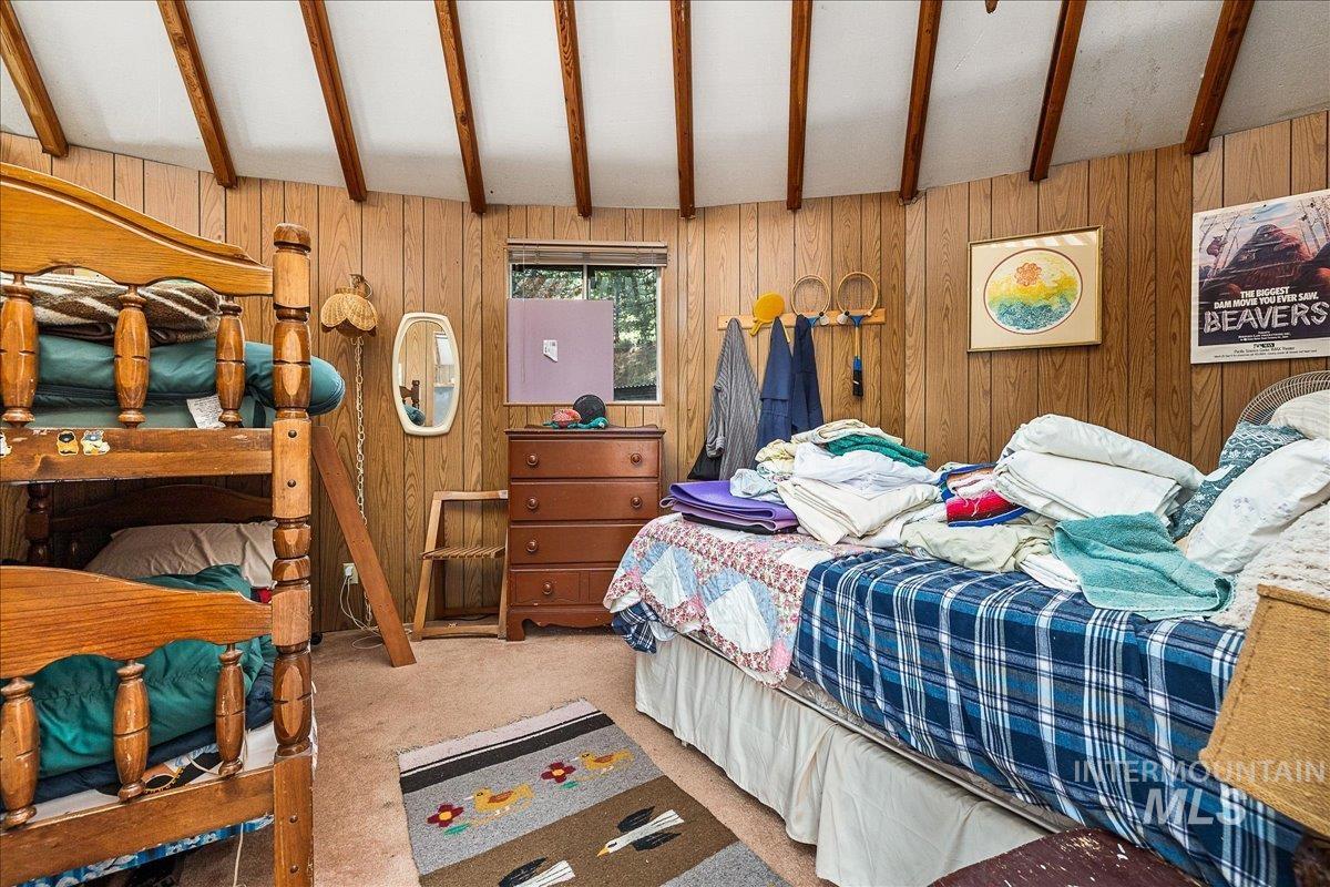 Bedroom featuring wood walls and carpet