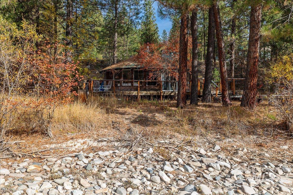View of front facade featuring a wooden deck, a gazebo, and a forest view