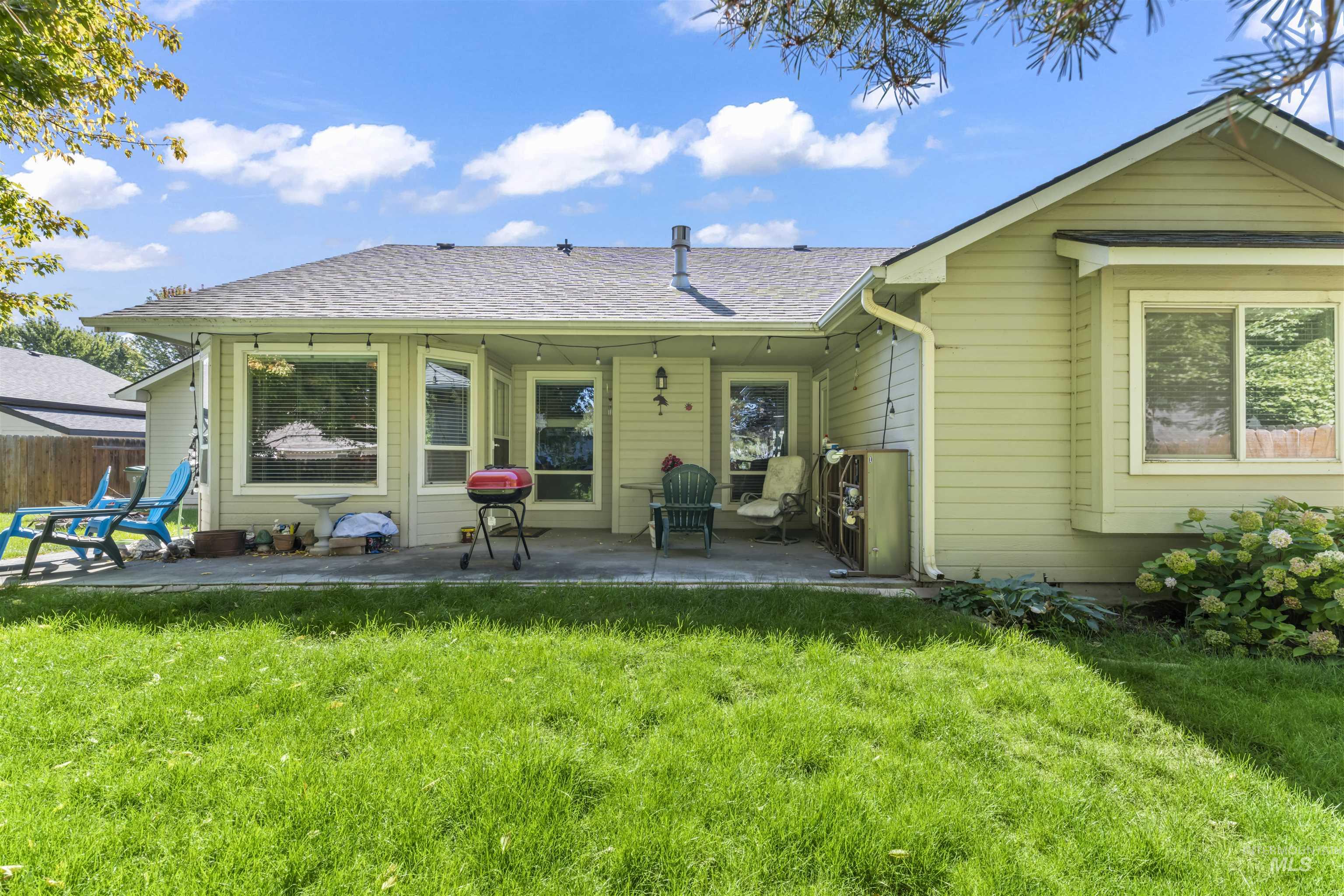 Rear view of house with a patio and roof with shingles
