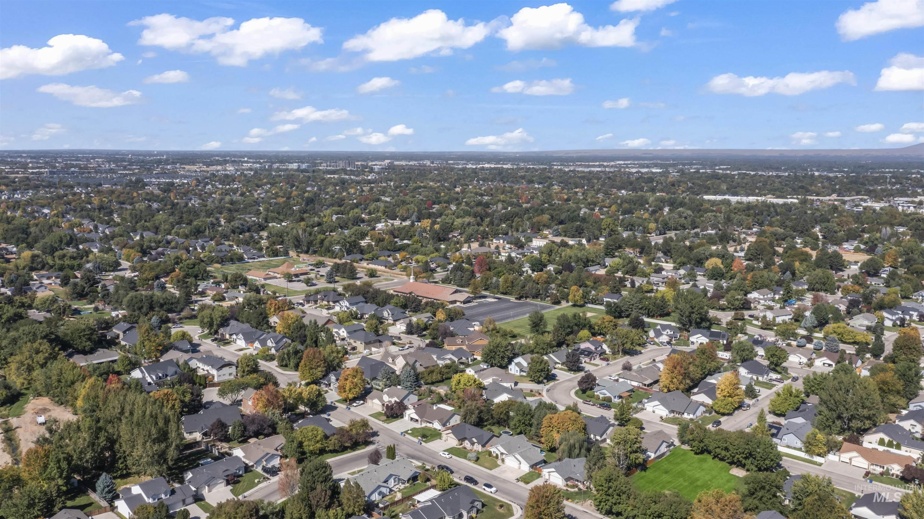 Aerial view of property and surrounding area with nearby suburban area