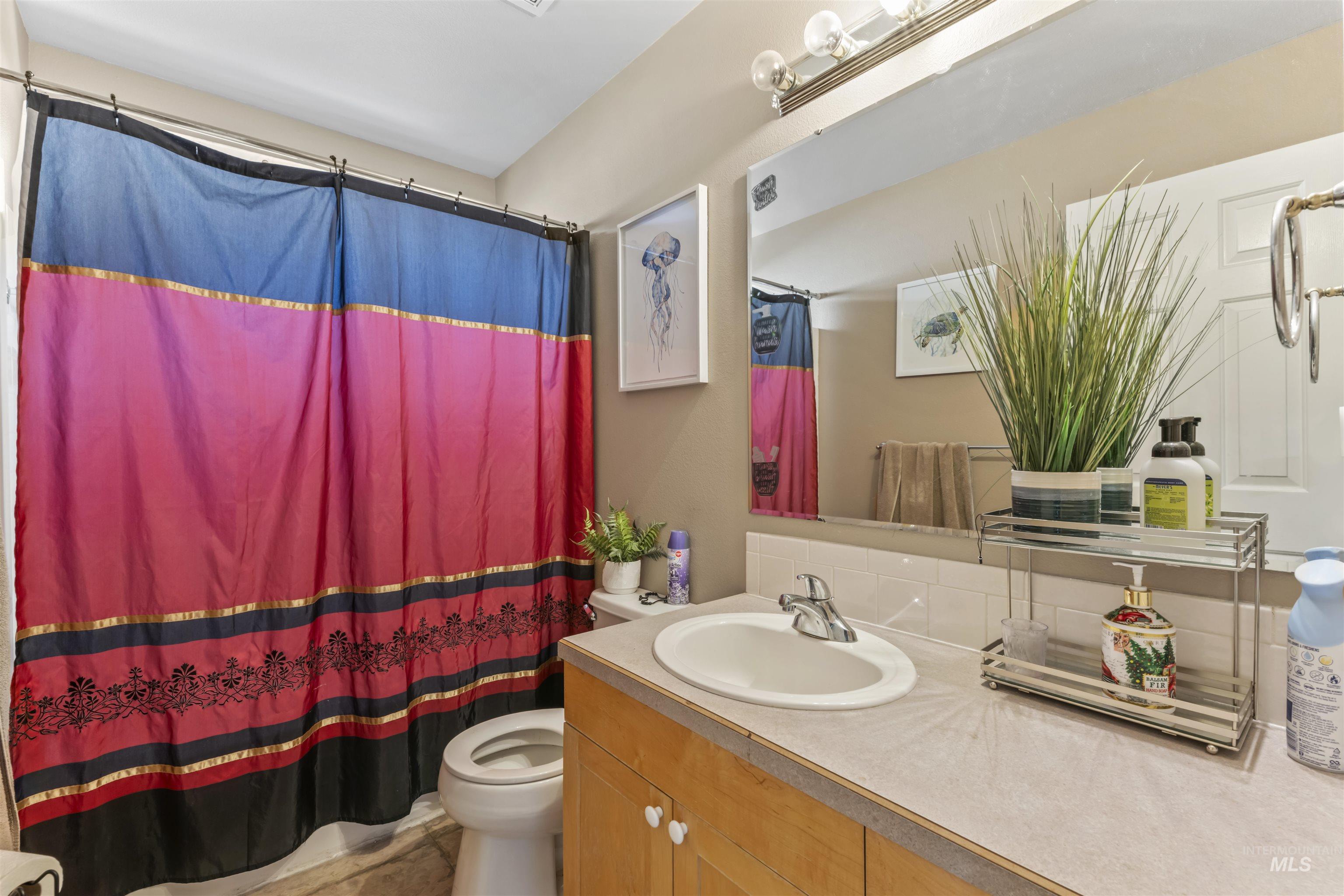 Bathroom featuring vanity and tasteful backsplash
