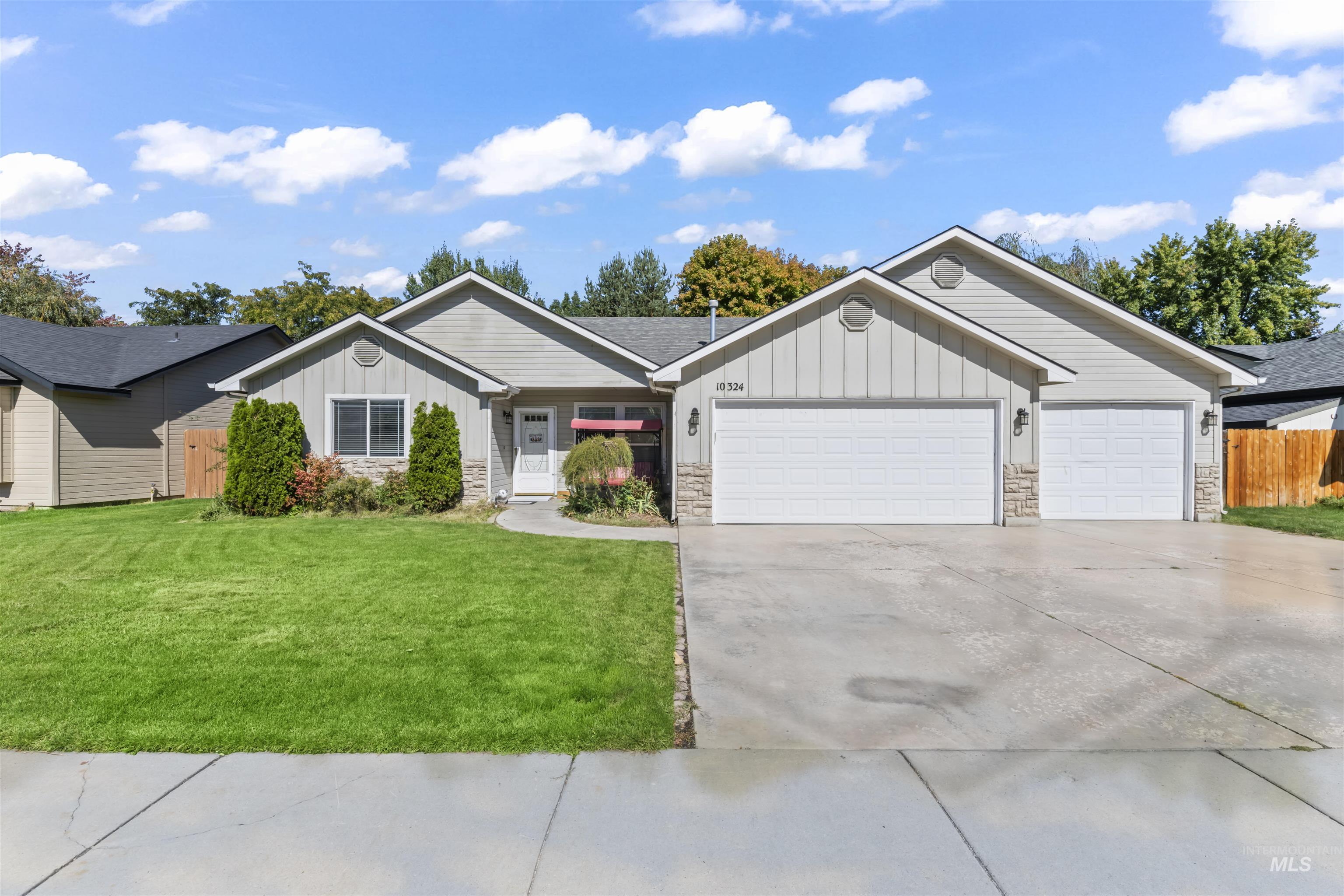 Ranch-style house featuring stone siding, board and batten siding, concrete driveway, and an attached garage