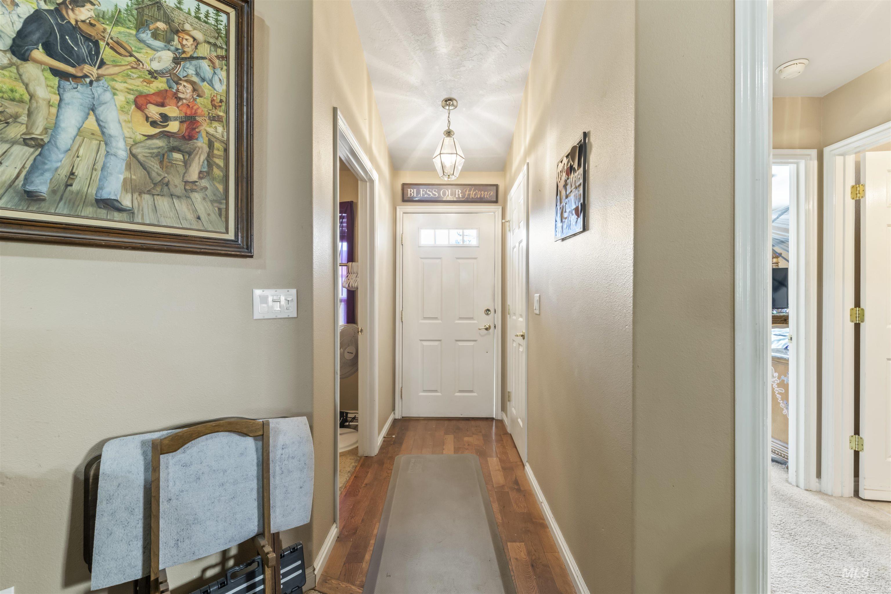 Doorway to outside with wood finished floors and baseboards