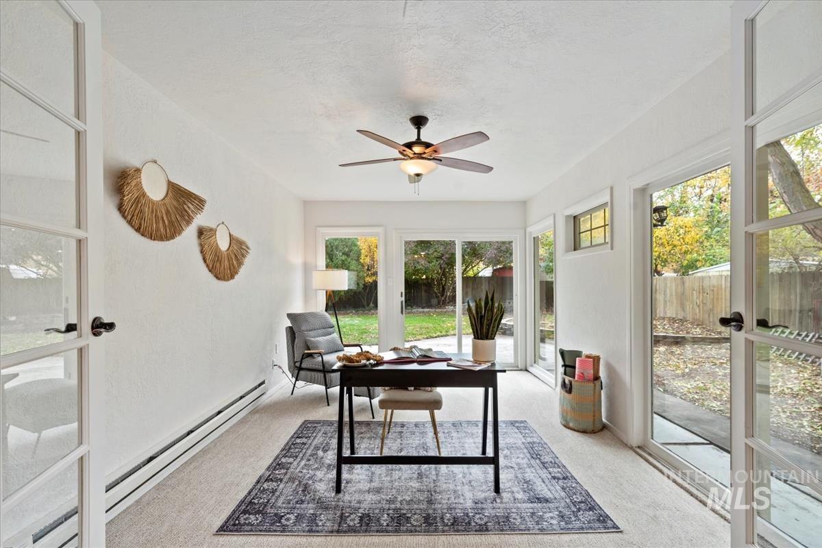 Office featuring baseboard heating, carpet, a ceiling fan, and french doors