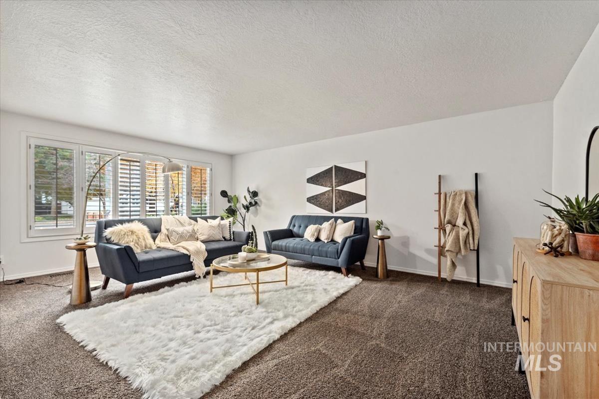 Living area featuring a textured ceiling and dark colored carpet